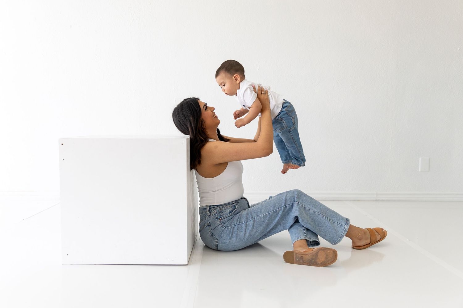 Minimalist white studio photos showing casual family interactions and poses.