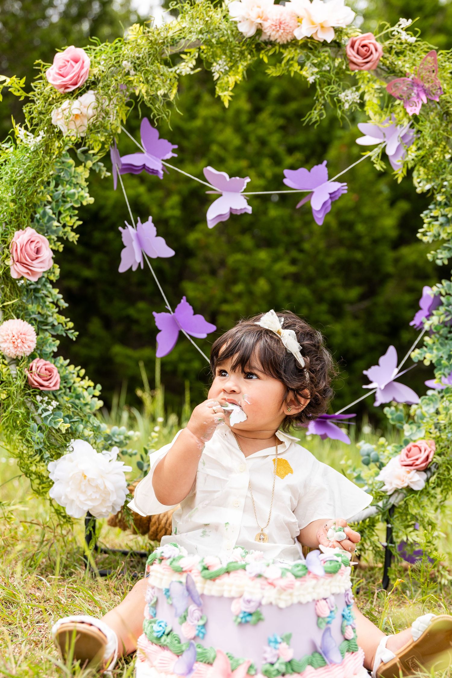 Enchanted garden setting with hanging purple flowers and pink roses for photos.