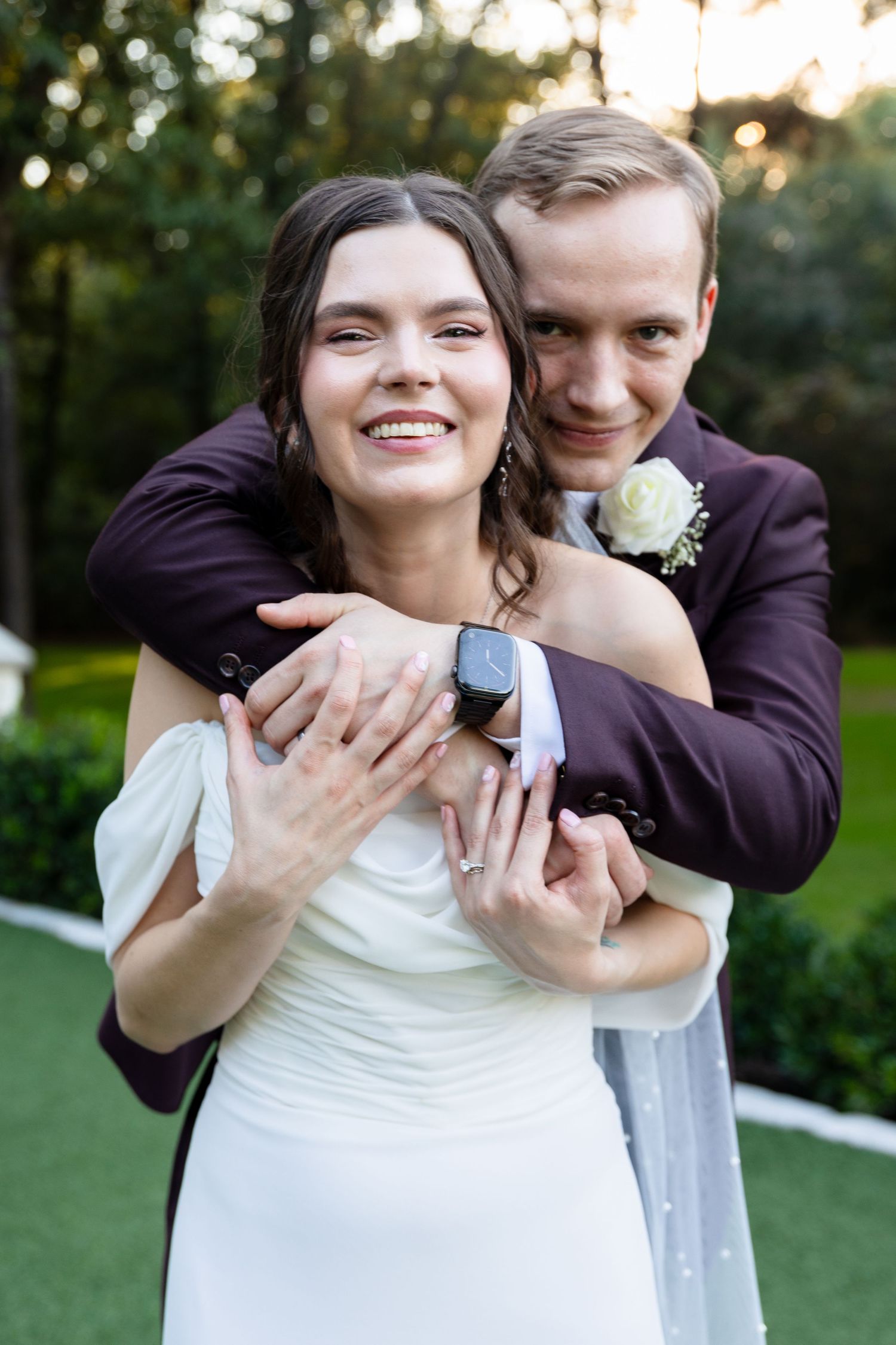Candid wedding portraits showing joyful embraces in a garden setting.