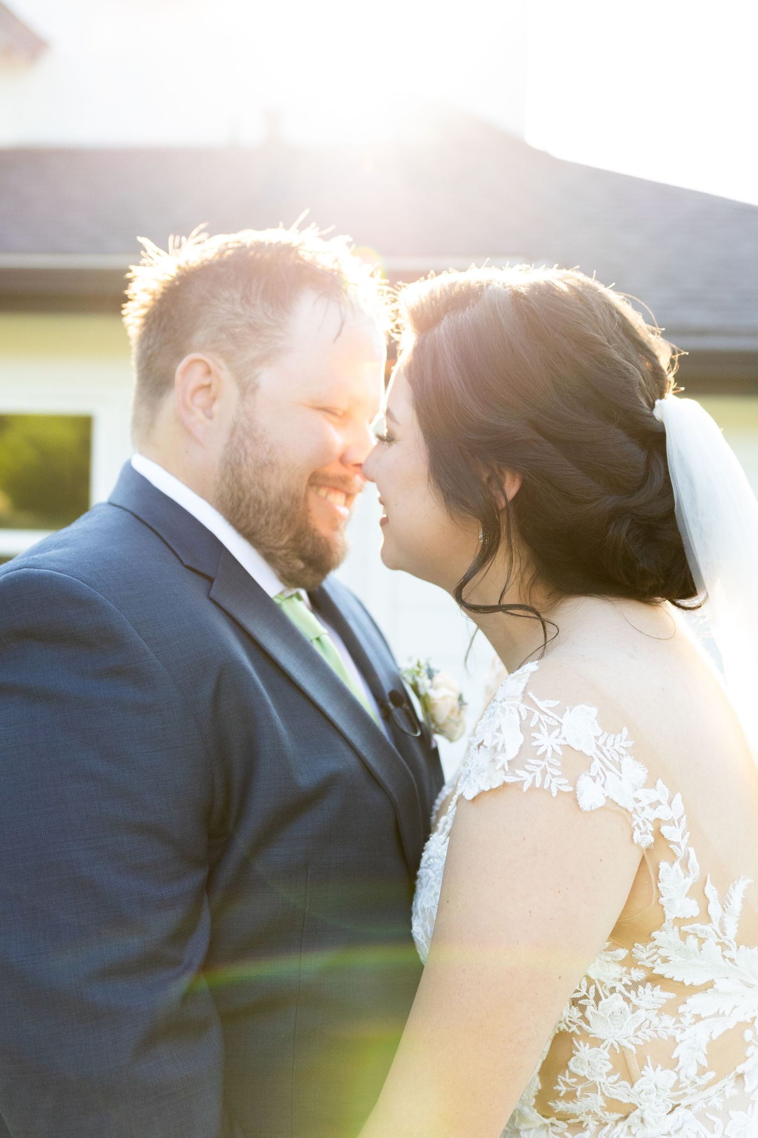 Romantic sunset portrait of couple in wedding attire with backlit glow.