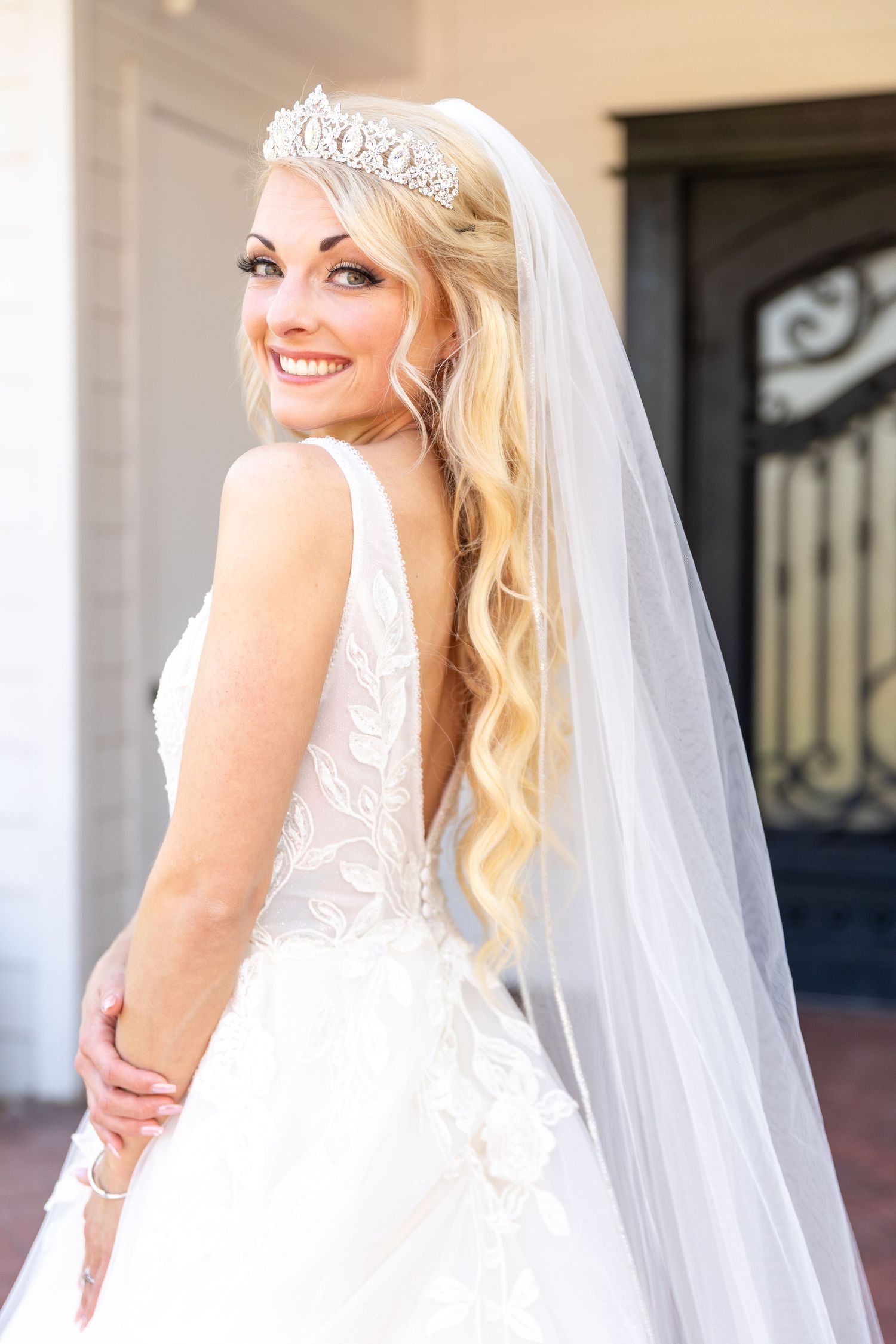 Elegant bridal portraits showcasing lace wedding dress and flowing veil in natural light.
