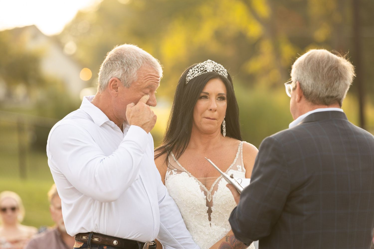 Wedding party gathered outdoors during golden hour sunset.