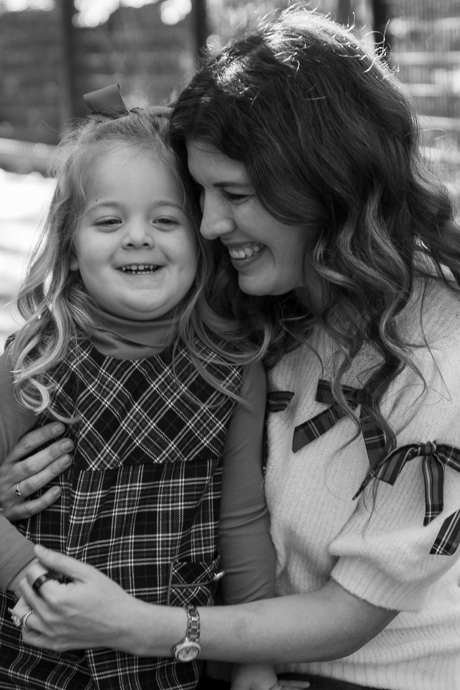 Black and white portrait of intimate family moment showing affection and laughter.