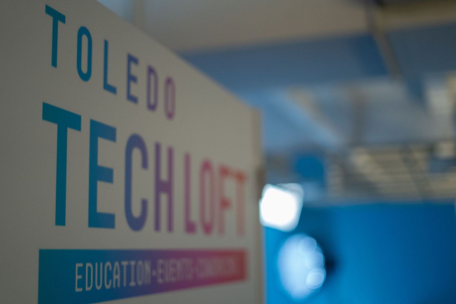 Toledo Tech Loft sign featuring education, events, and coworking services in modern office space.