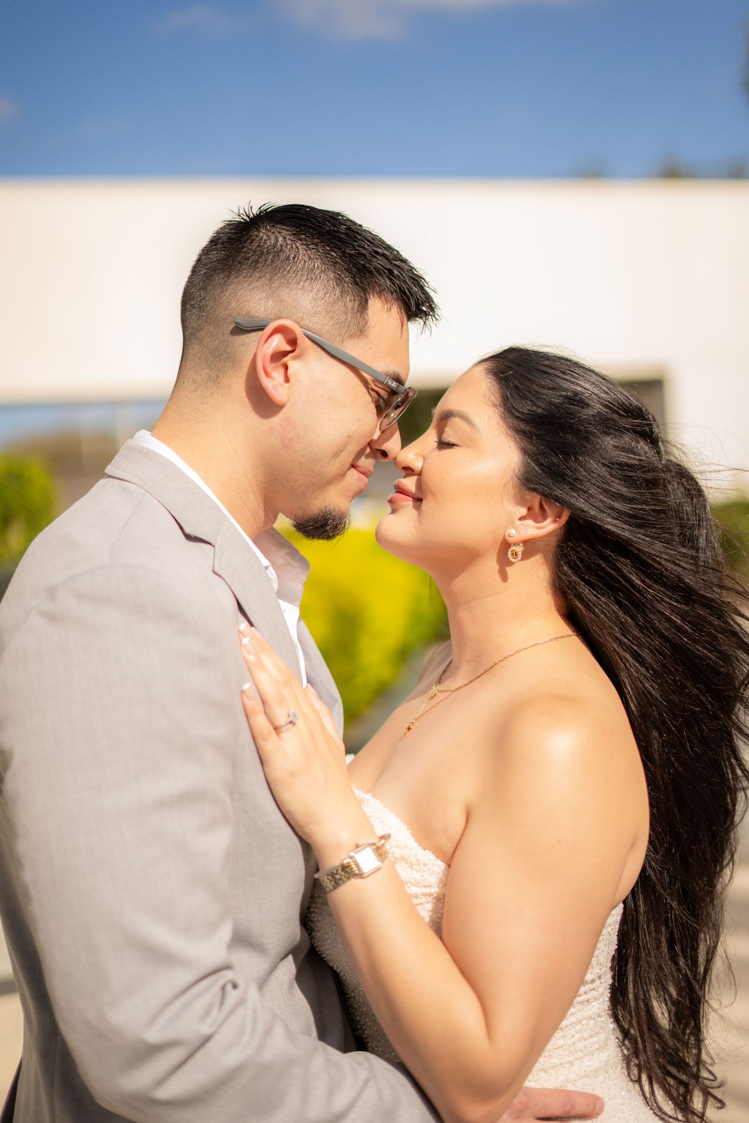 Couple sharing romantic moment almost kissing outdoors on sunny day.