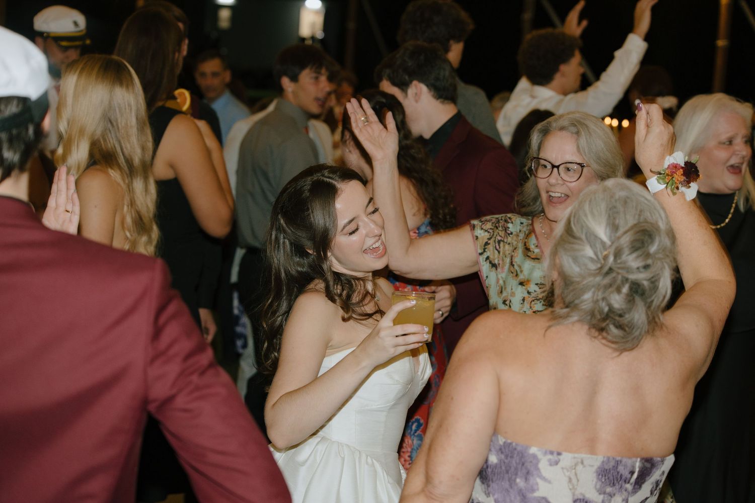 A group of wedding guests dancing together on a dance floor during a celebration.