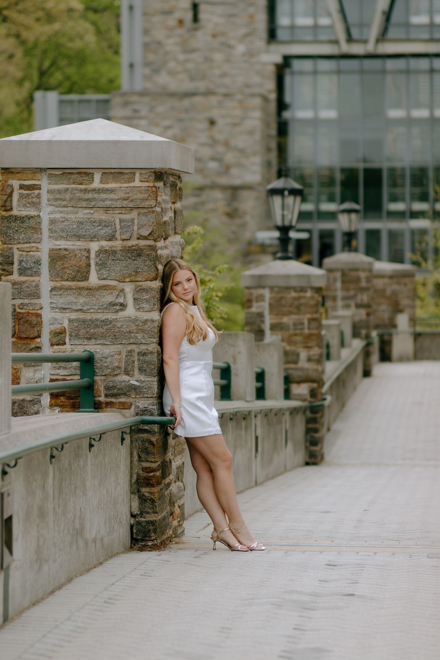 Creative poses along a stone walkway with traditional lamp posts and building facade.