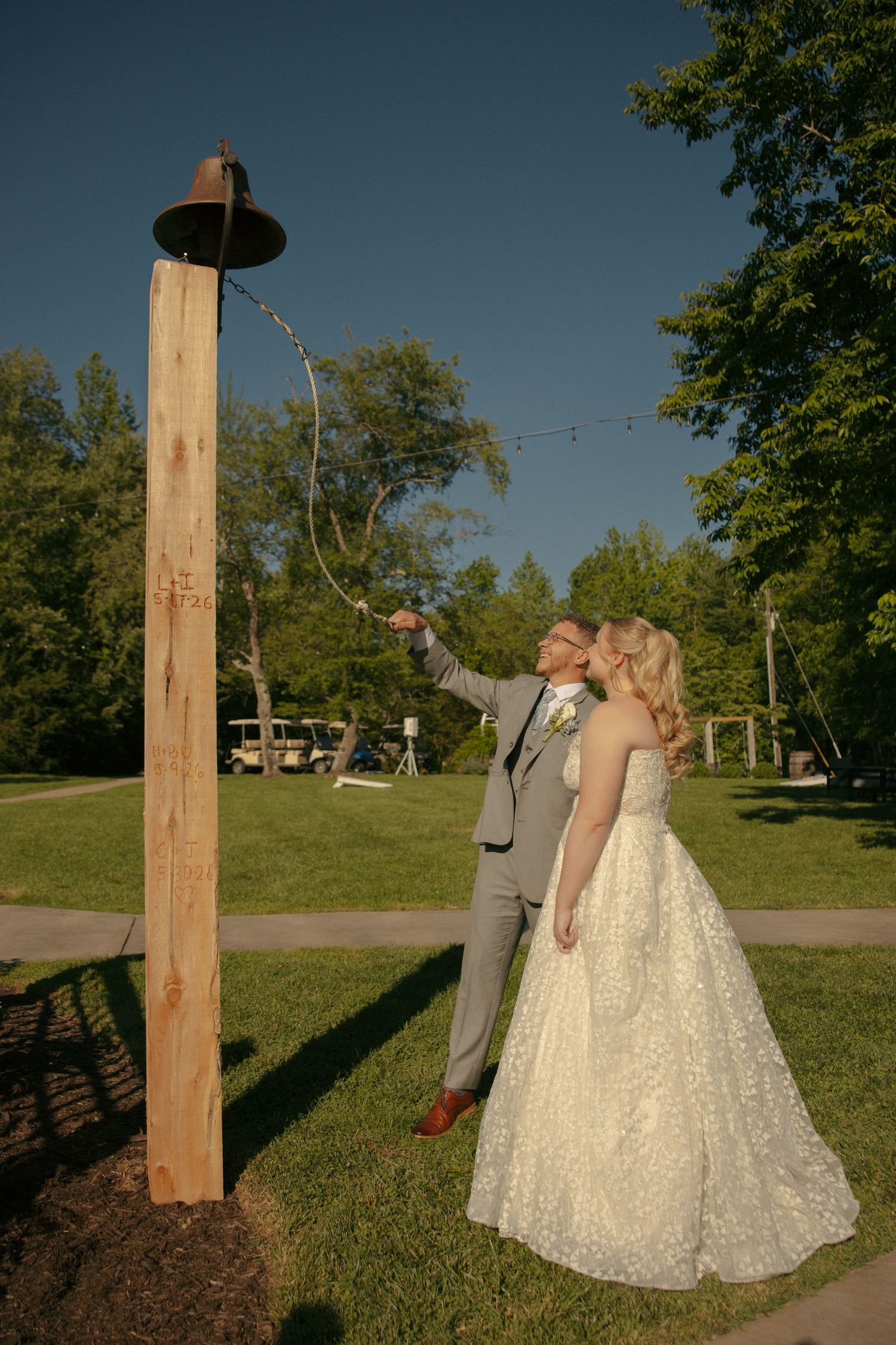 Bride and groom ringing the bell at Avonlea Farms in Mineral, VA. at outdoor wedding in the summer. Virginia Wedding Photographer