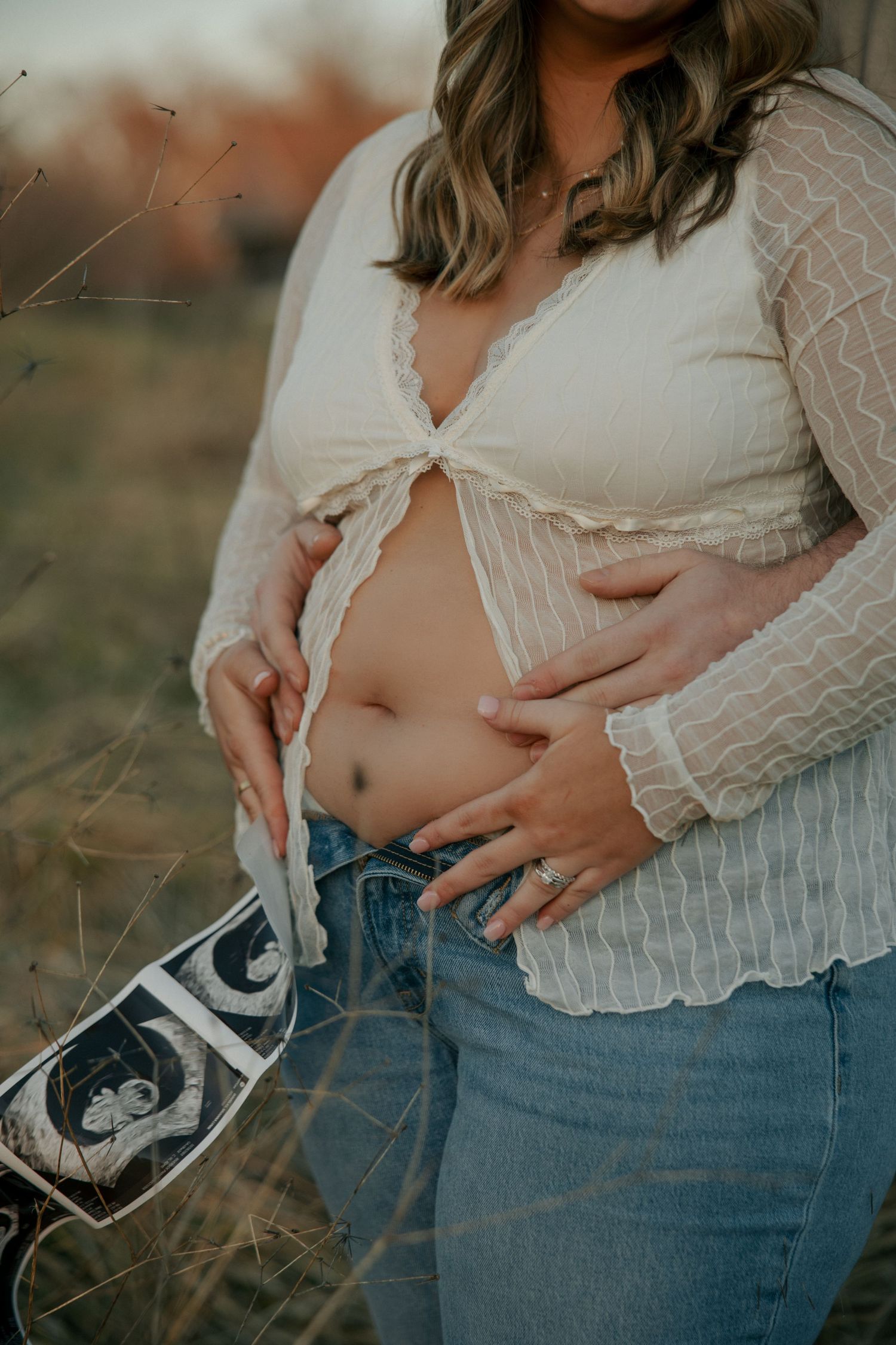 detail photo of baby bump with sonogram at golden hour pregnancy announcemnt photoshoot at Machicomoco state park in gloucester, va