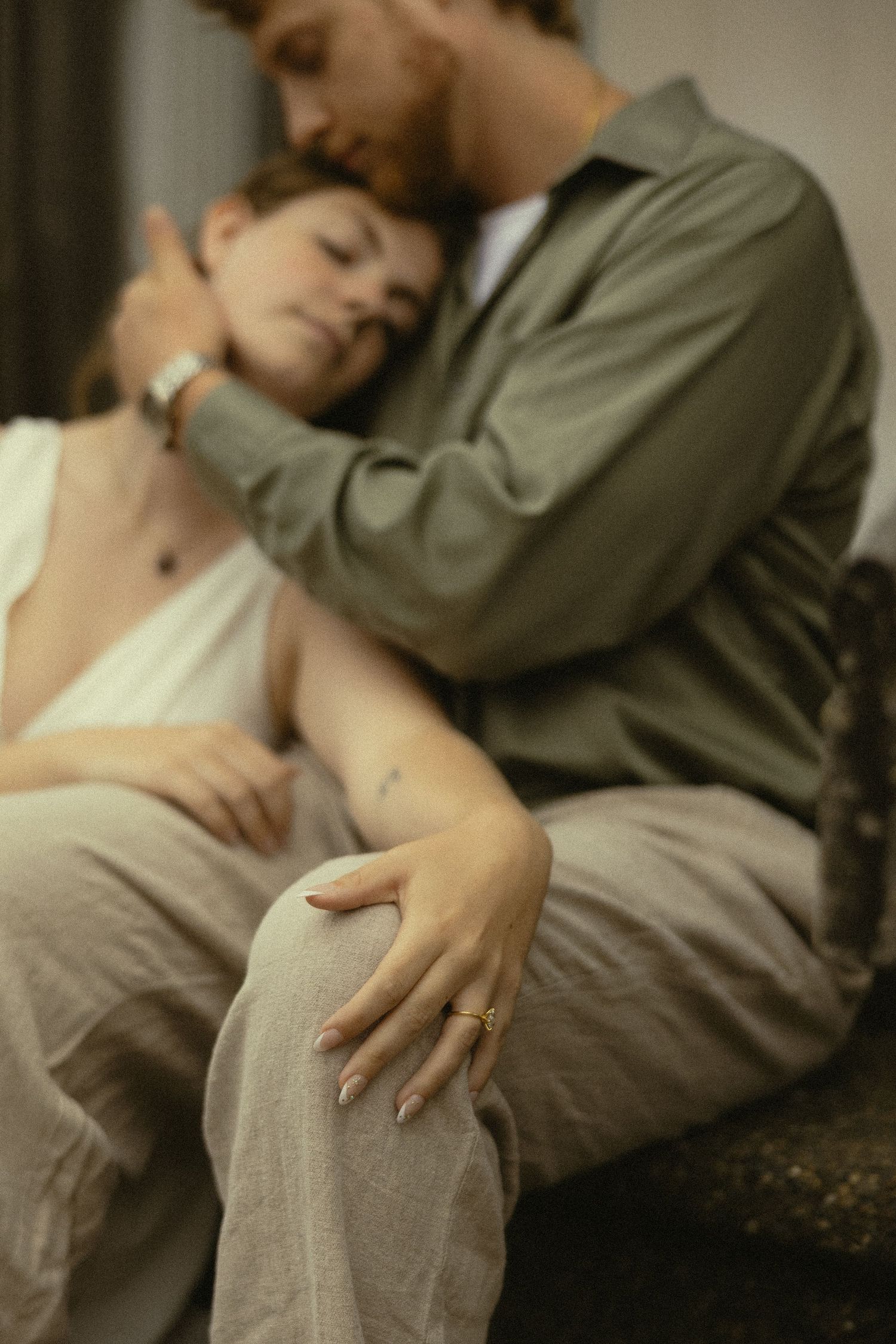 Couple embracing tenderly, woman resting head on mans shoulder while he holds her close.
