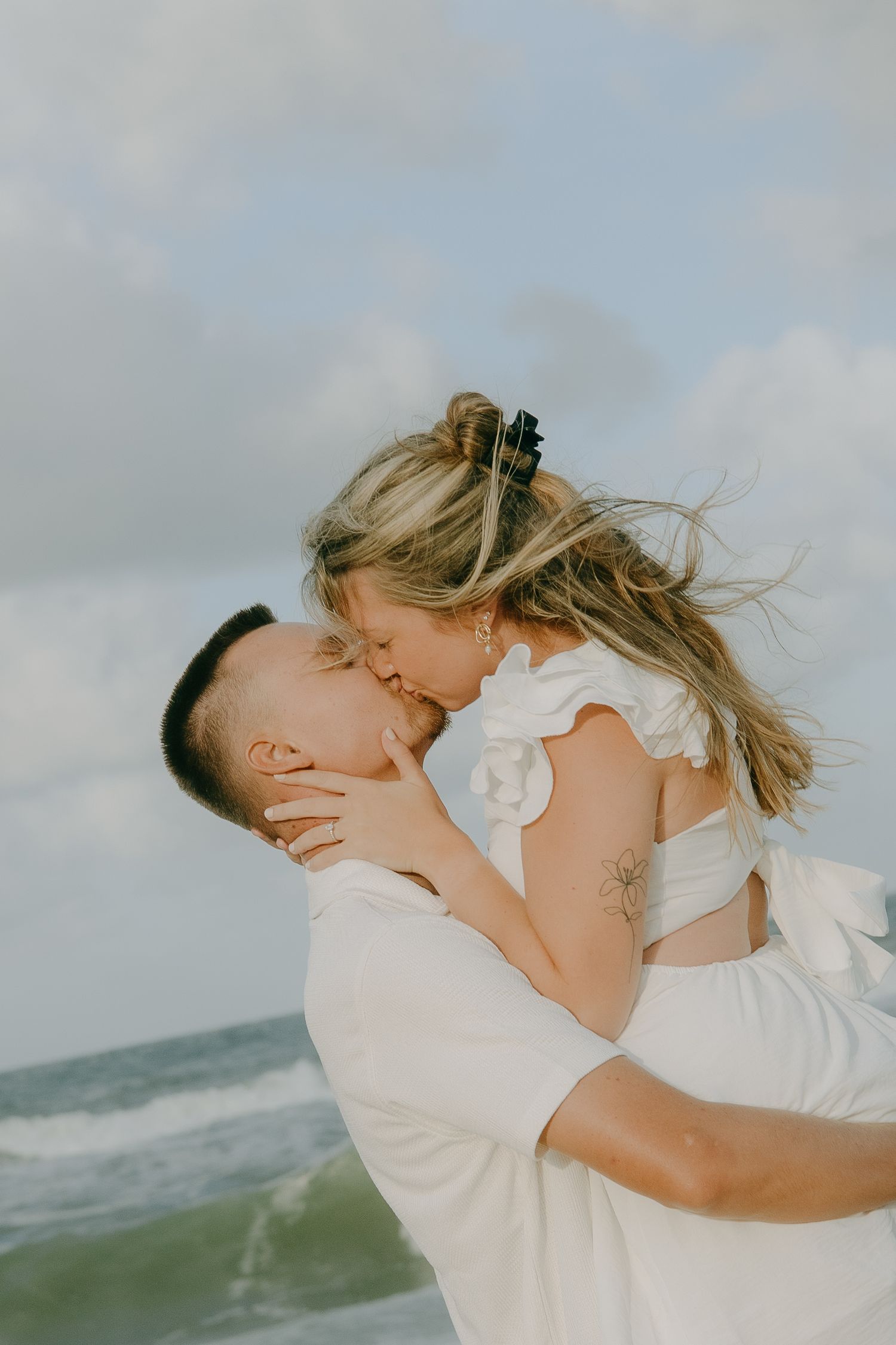 An intimate moment shared between a couple on a cloudy beach.