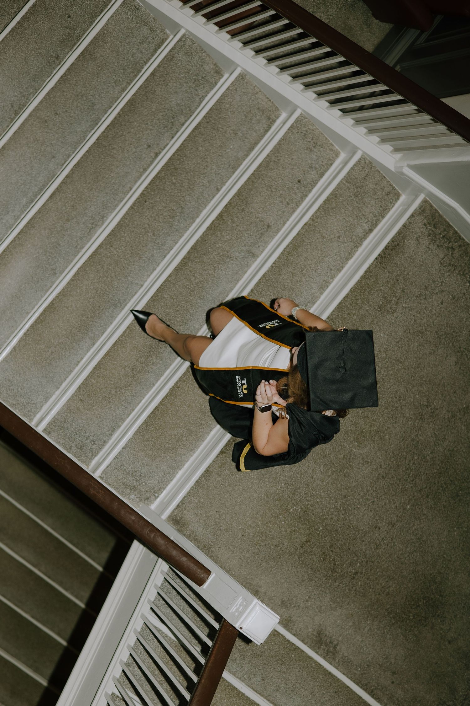 Overhead view of a backpack and laptop bag sitting on concrete stairs with white railings.