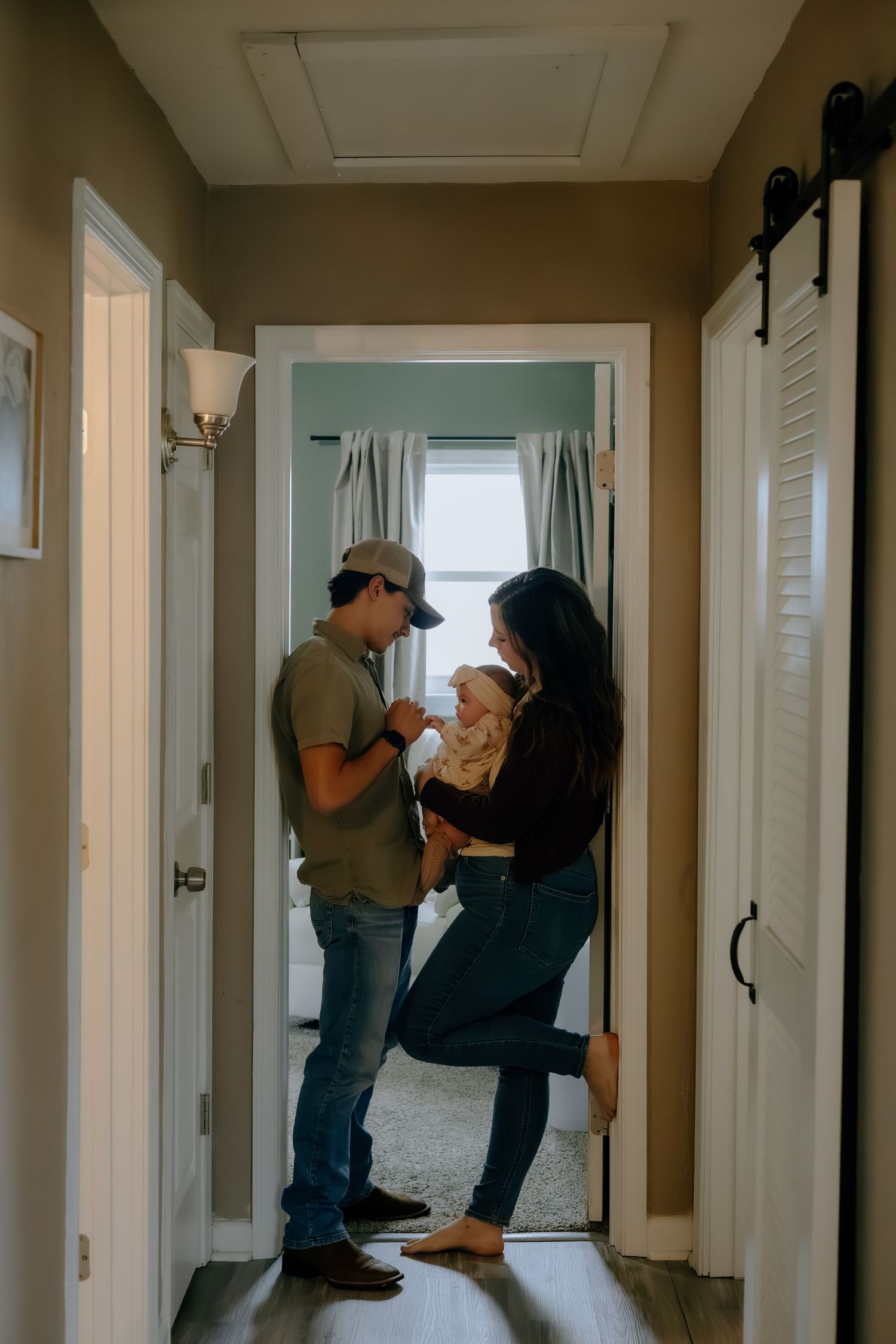 People standing in a hallway of a home during what appears to be a casual gathering.