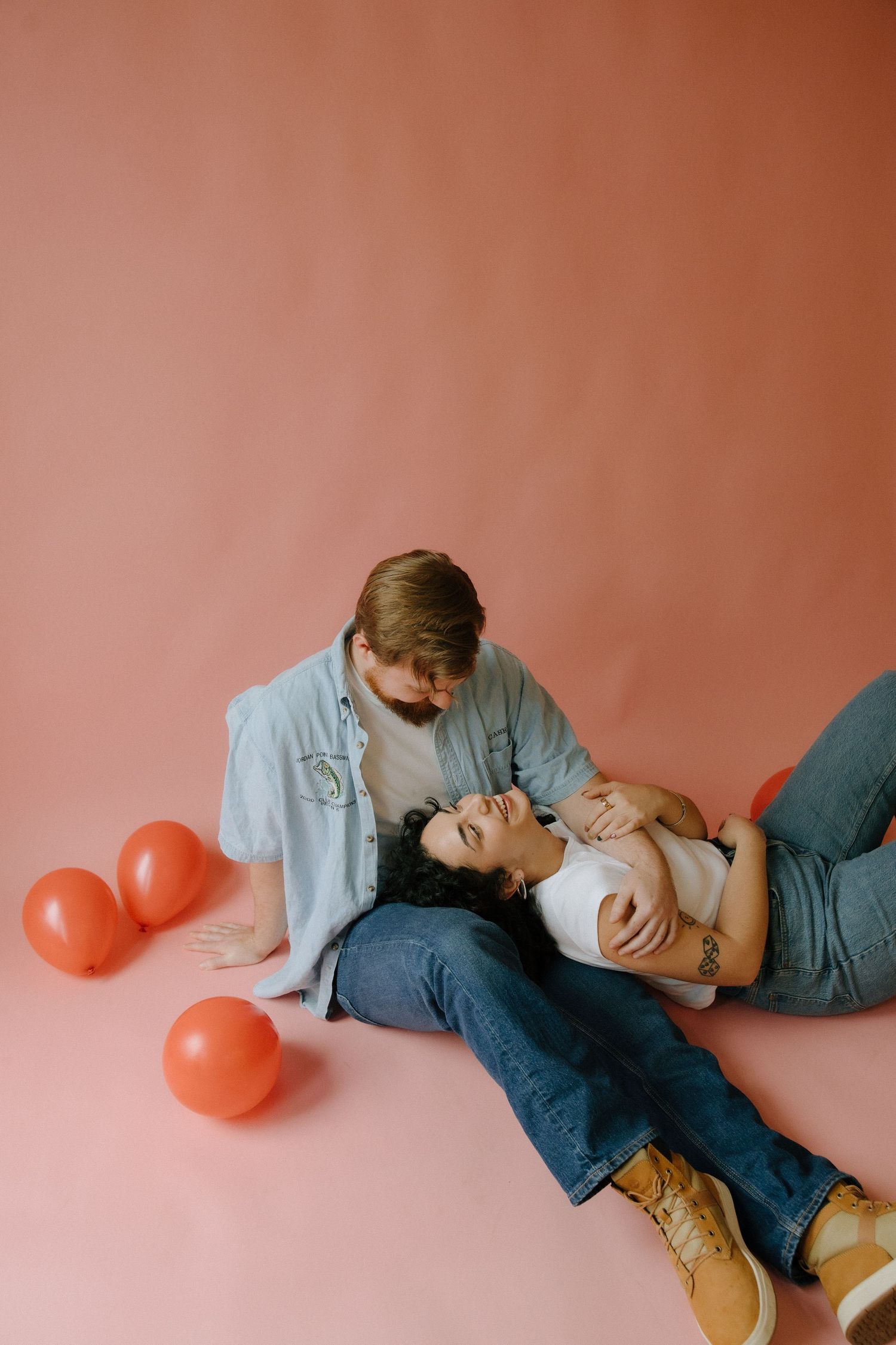 couples session for valentines day in a studio in richmond virginia with a pink backdrop