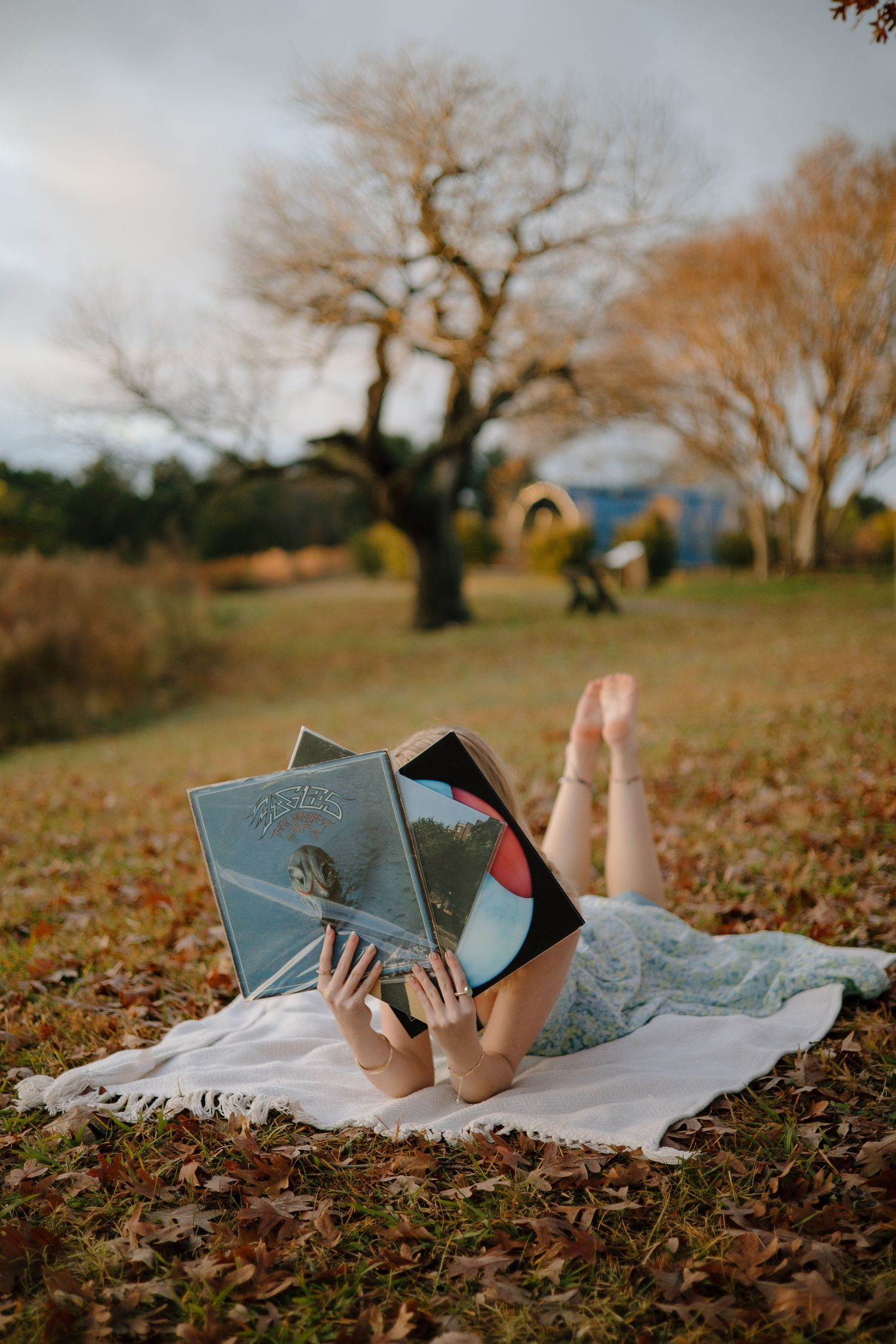 fall senior photoshoot with records/vinyls in a field at machicomoc state park in gloucester, va shot by virginia senior photographer