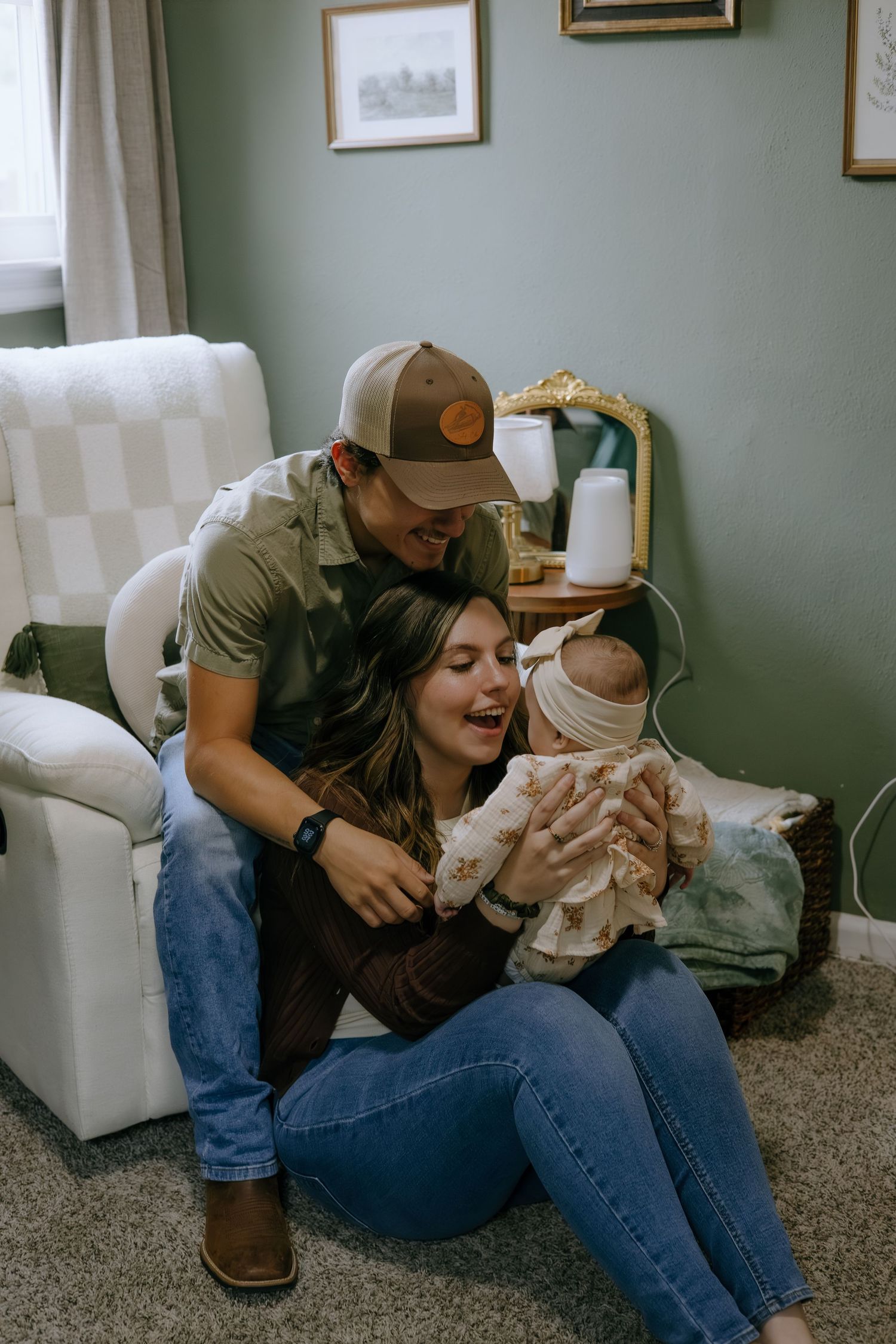 Playful interaction with a baby wearing a white outfit on a comfortable couch.