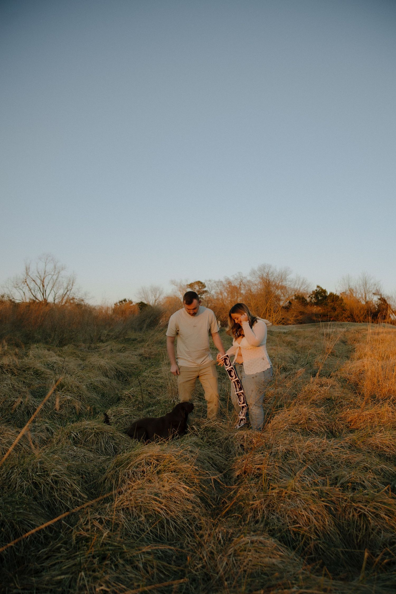 Golden Hour Pregnancy Announcement photoshoot at Machicomoco State Park with their dog in Gloucester, VA shot by a virginia photographer