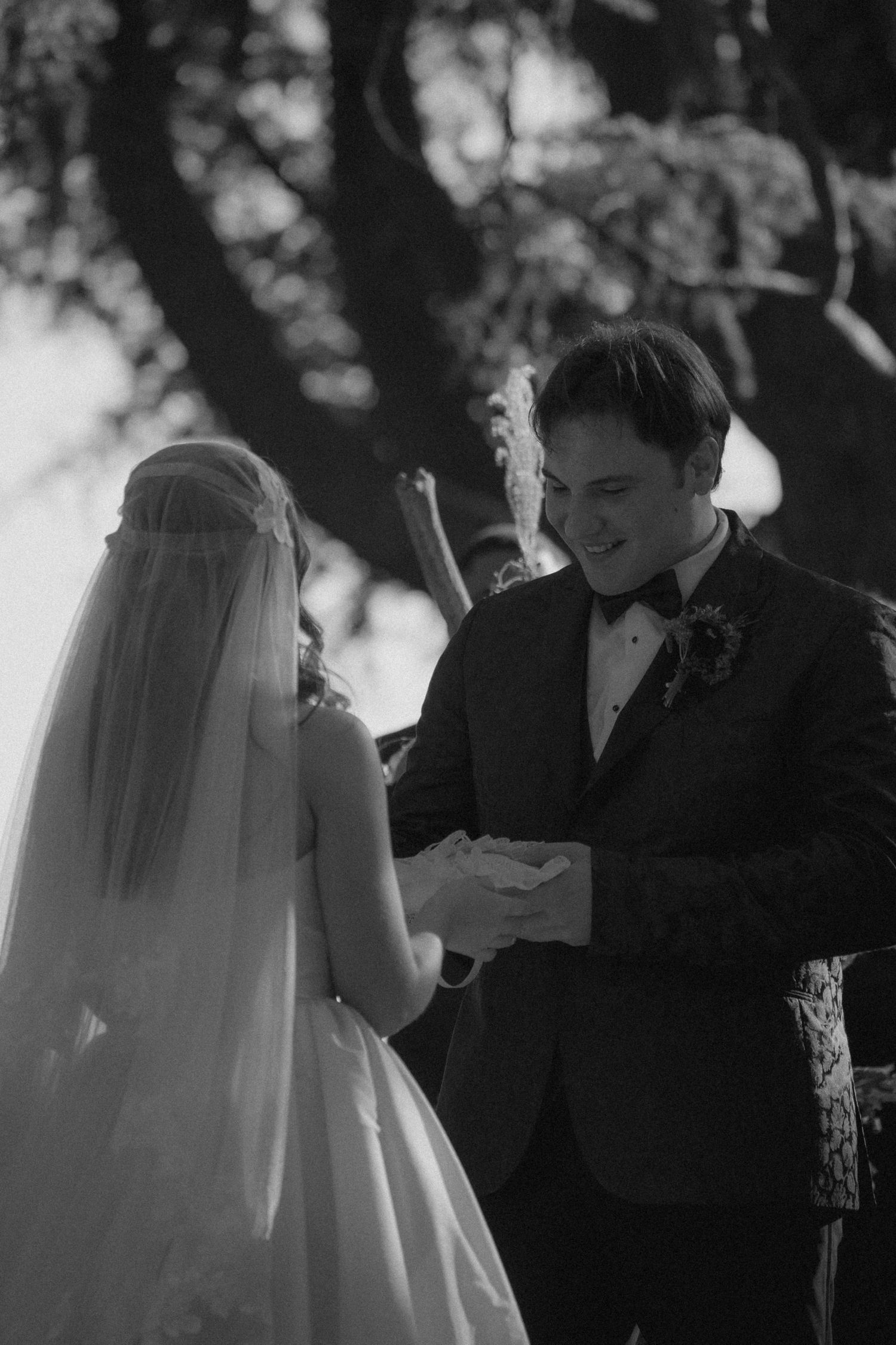 black and white photo of wedding couple exchanging rings at the altar in Maryland captured by virginia wedding photographer