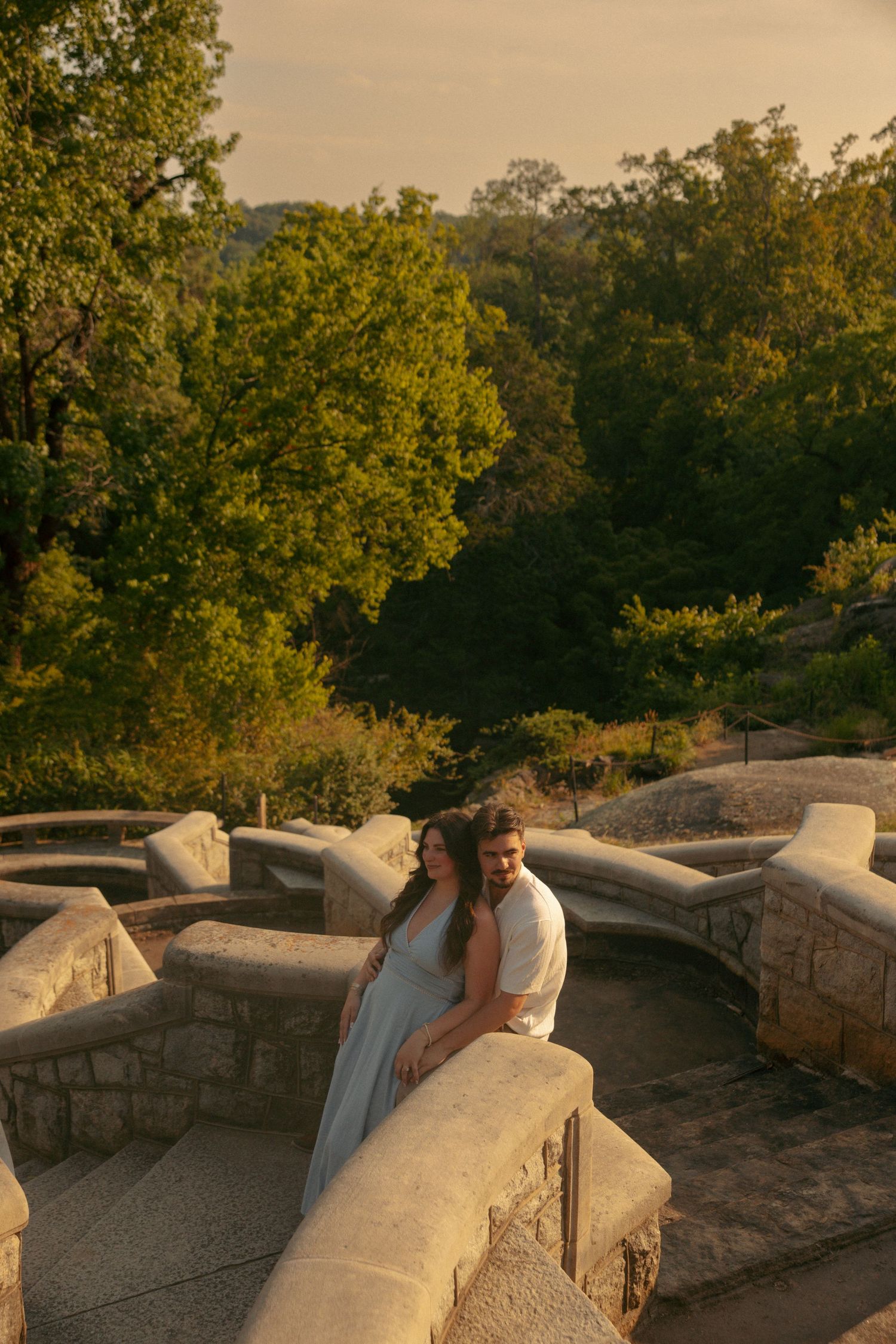 Couple embraces on stone steps surrounded by  during golden hour sunset at Maymont in richmond, va. virginia engagement photographer