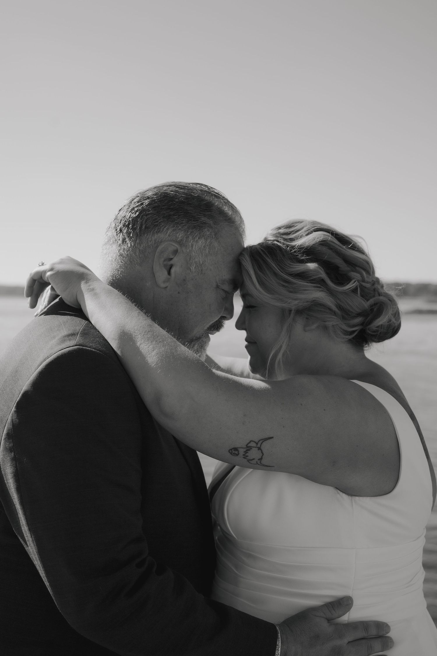 A romantic black and white photo sequence showing a couple sharing intimate kisses at the beach.
