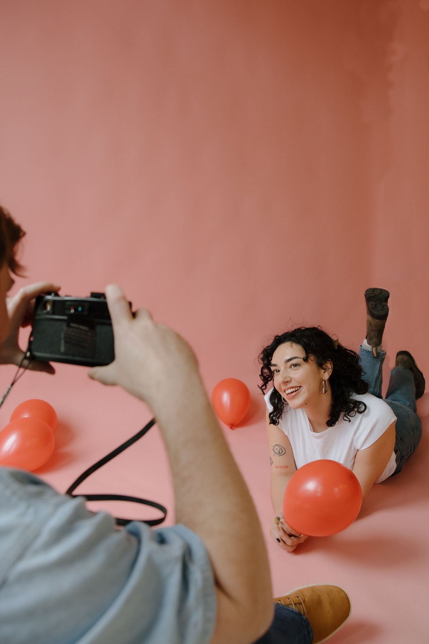 couple with film camera for valentines photoshoot in a studio in richmond virginia with pink backdrop