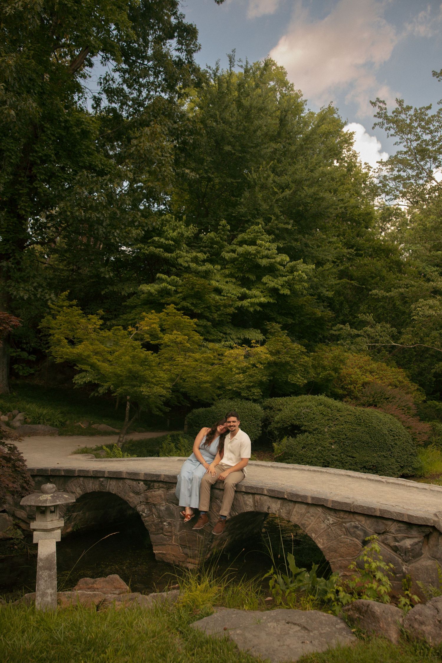 Couple sitting together on a stone arch bridge at Maymont in richmond, va. virginia engagement photographer