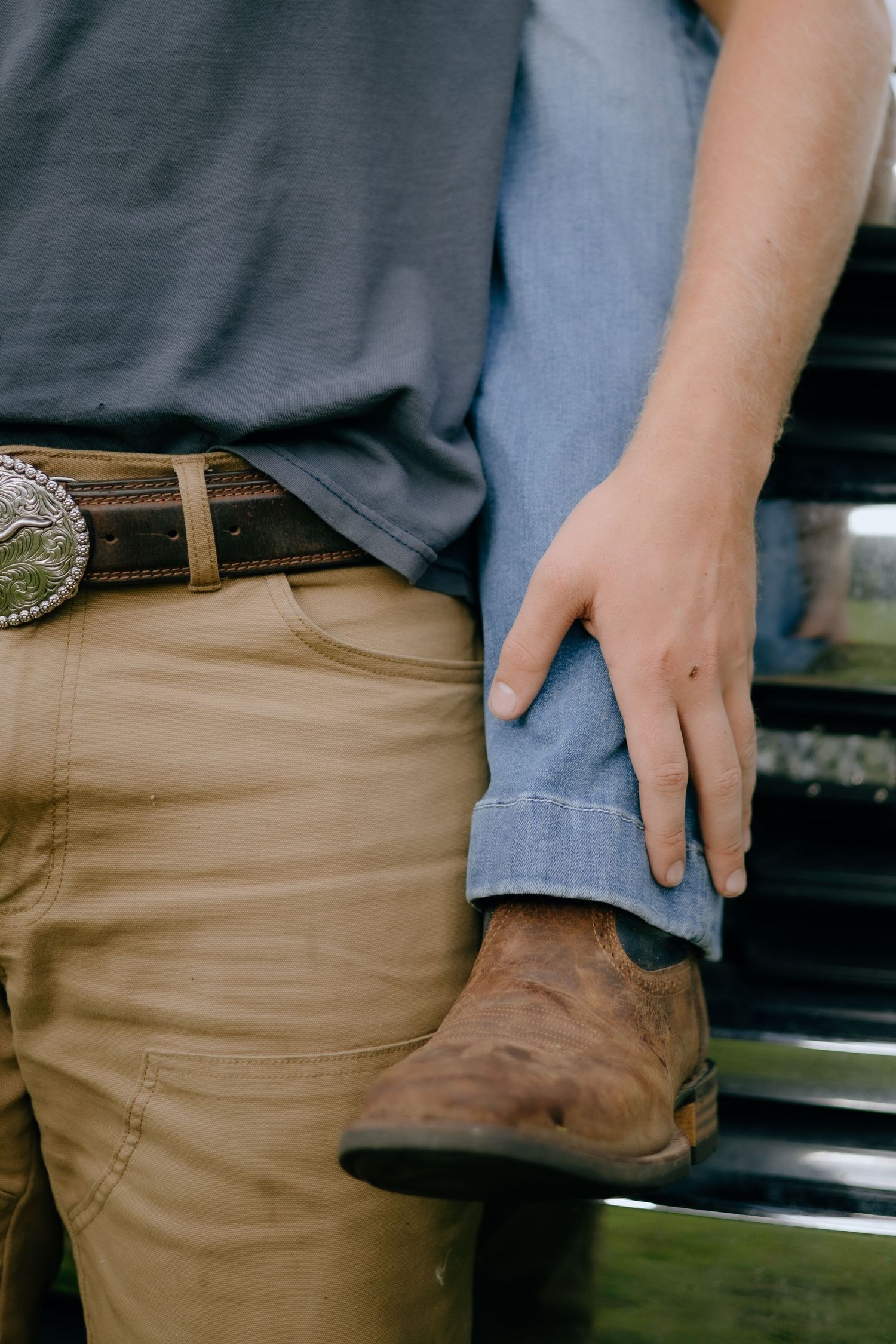 Close-up of brown boots and khaki pants against a dark background.