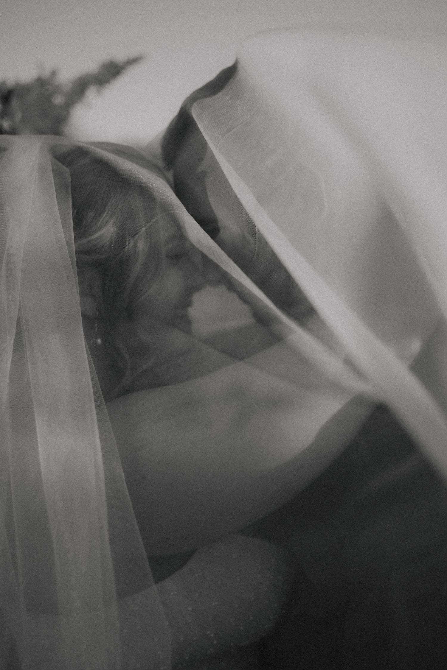 Artistic black and white portrait showing silhouettes through flowing fabric.