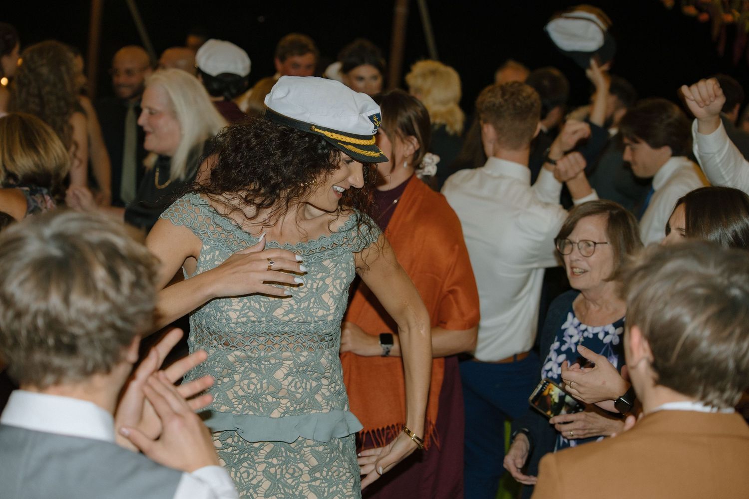 A group of people dancing and socializing at a formal event in an indoor venue.