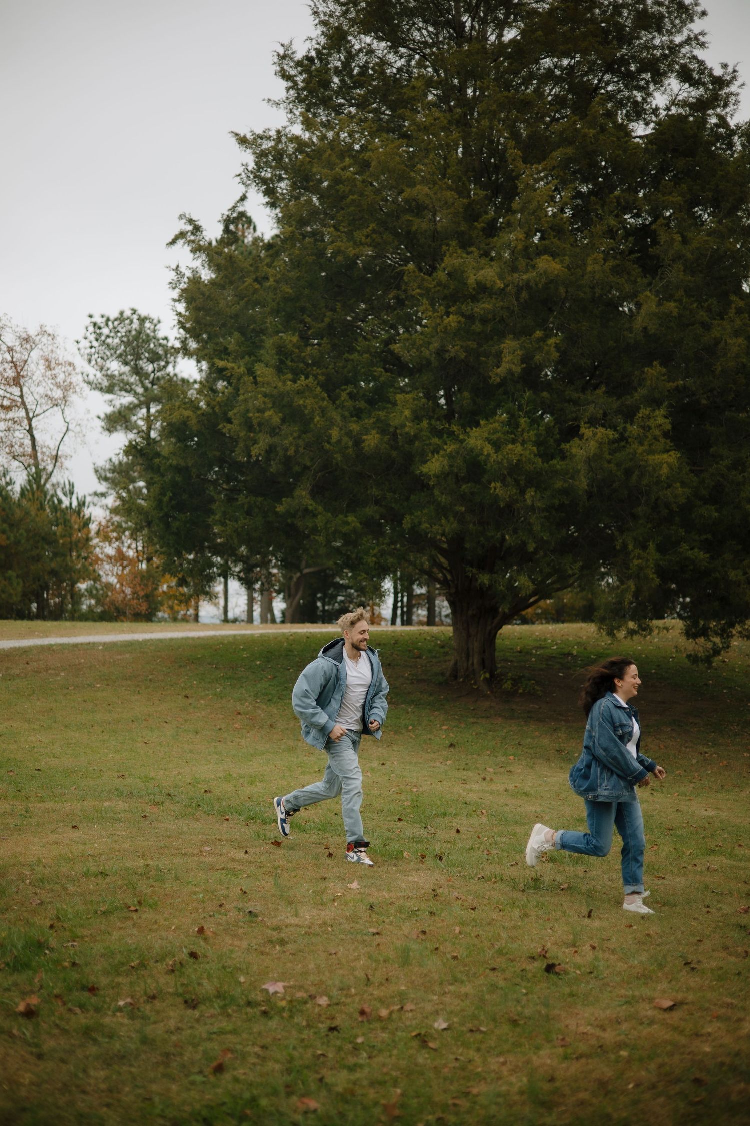 Playful sequence of someone running and jumping on a grassy hill during autumn.