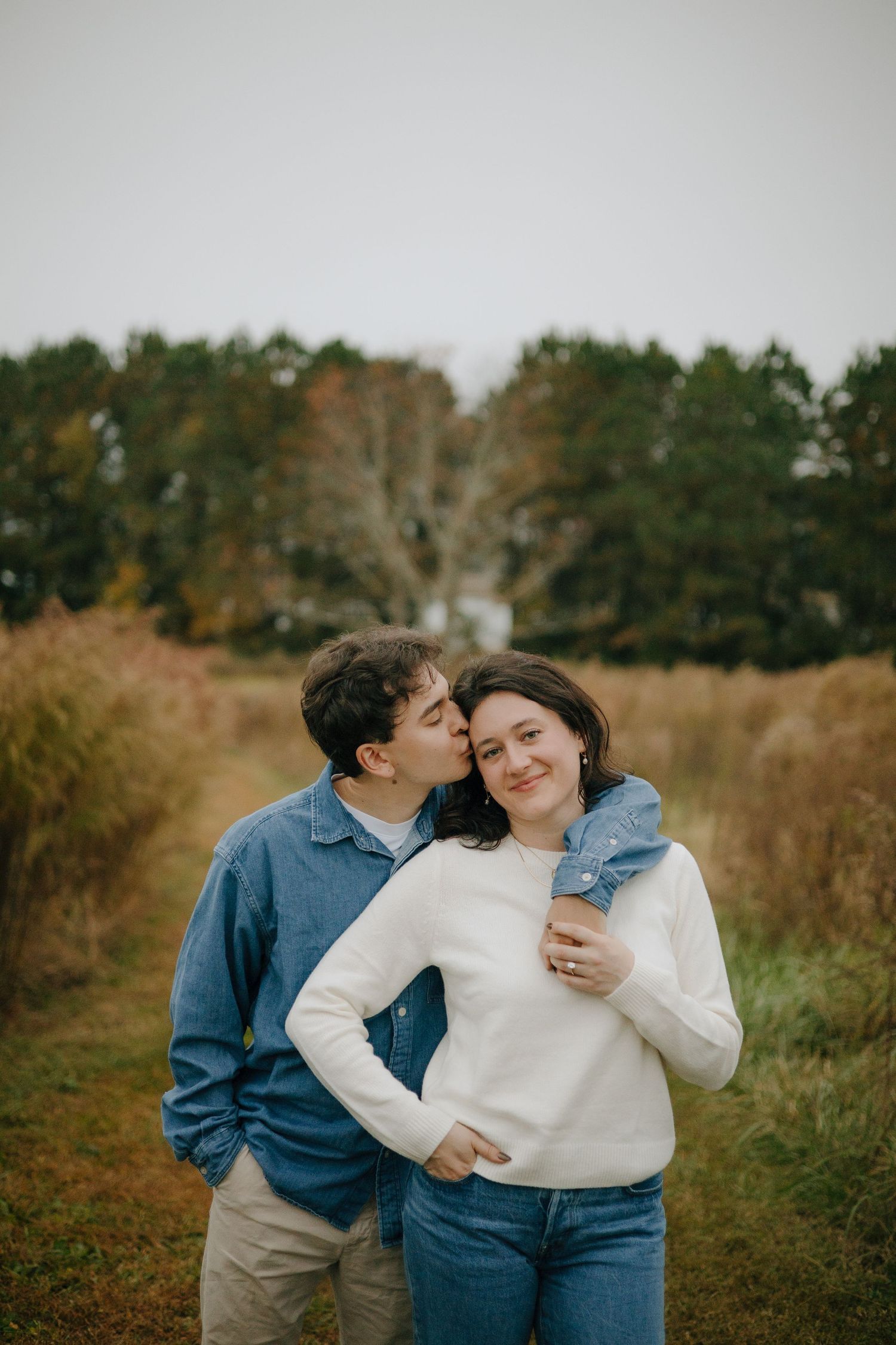 Sweet candid moments shared between a couple in a rustic autumn setting.