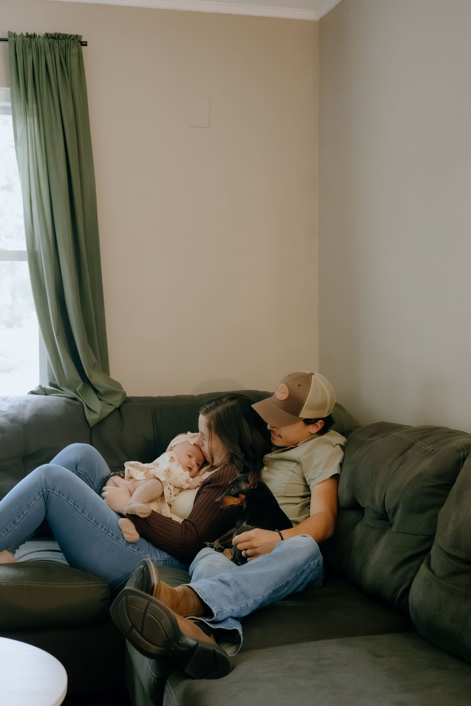 Relaxing afternoon scene on a dark gray couch with green curtains in background.