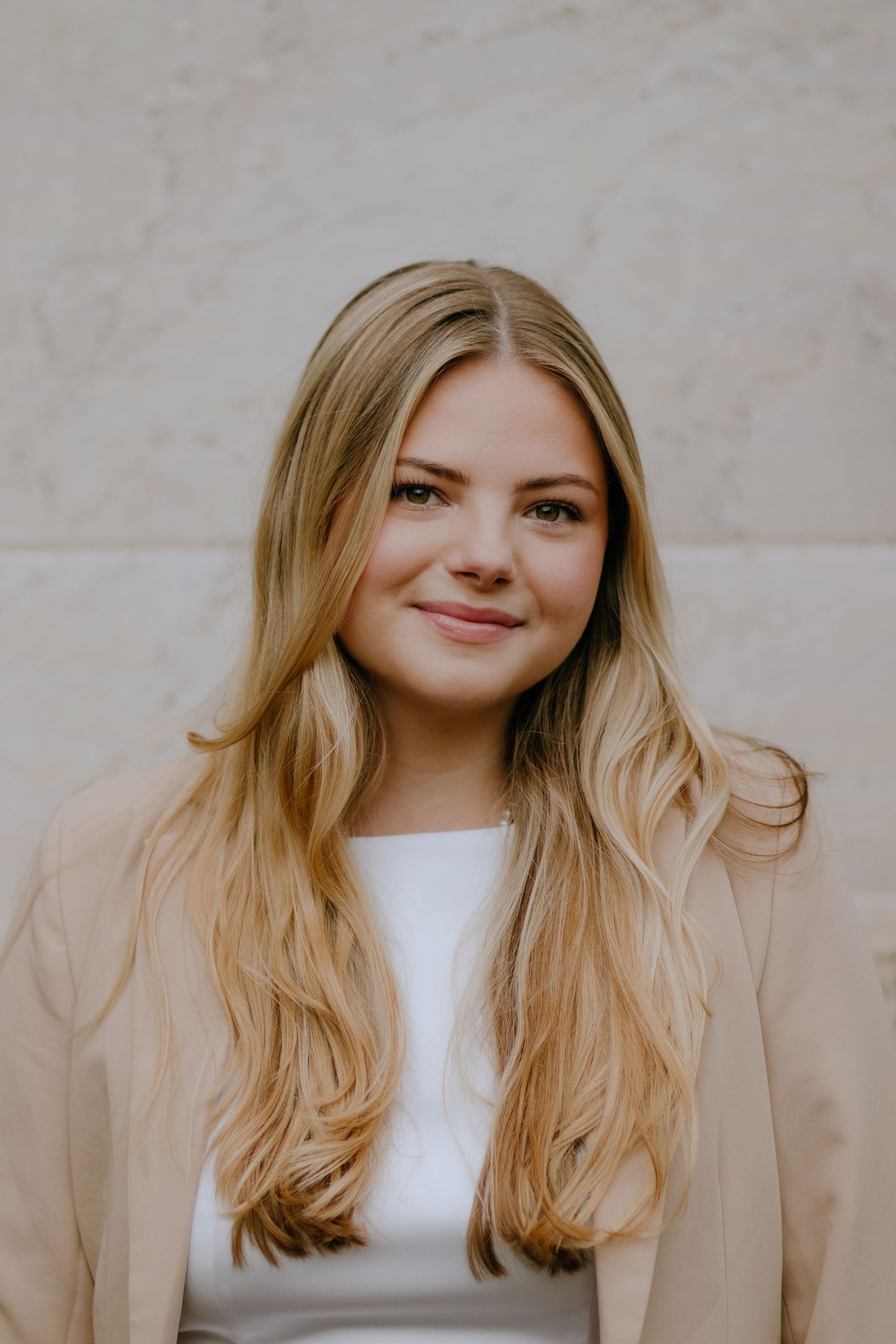 Professional headshot series against a neutral background showing warm expressions.