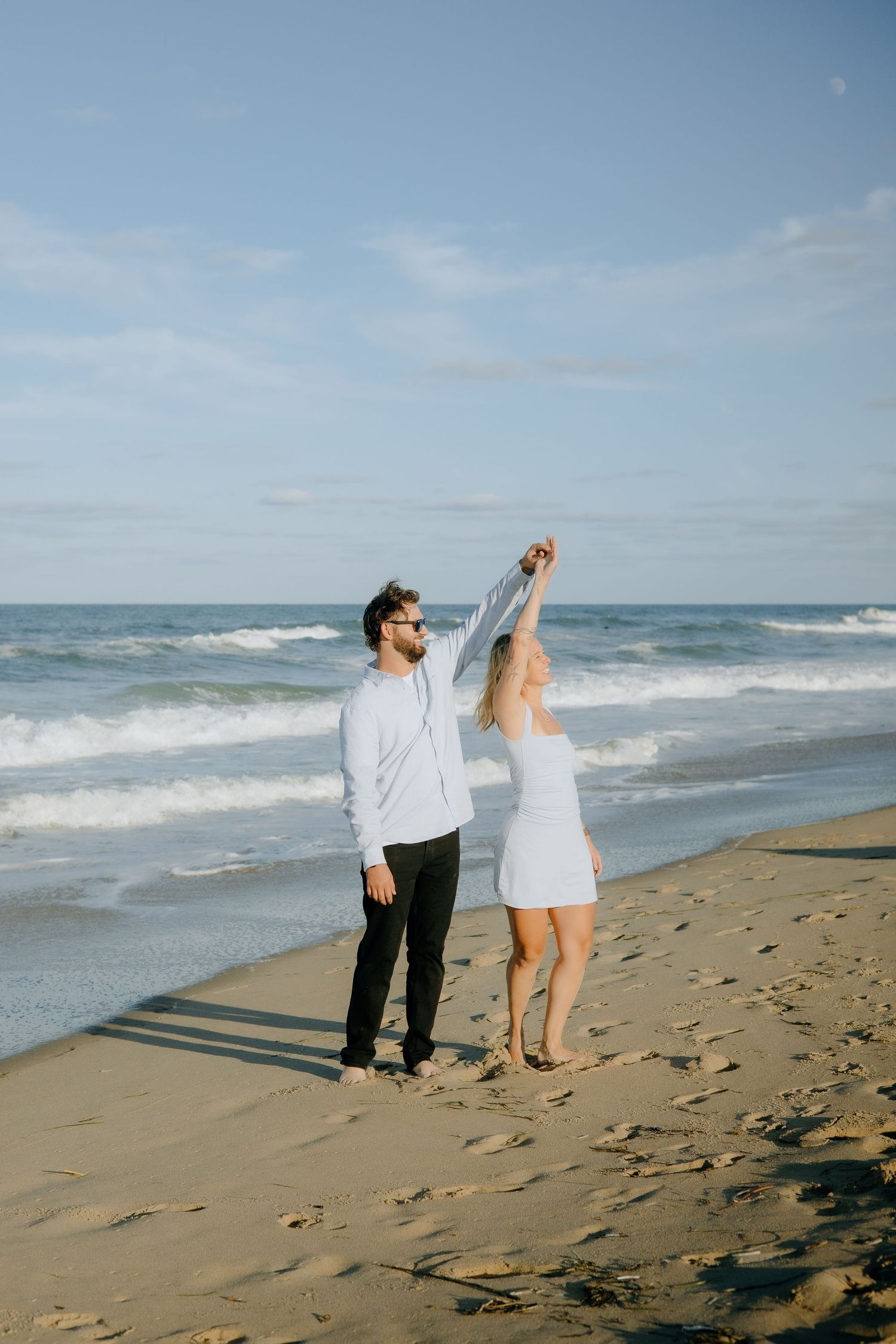 Couple walking and playing together along a scenic beach shoreline.