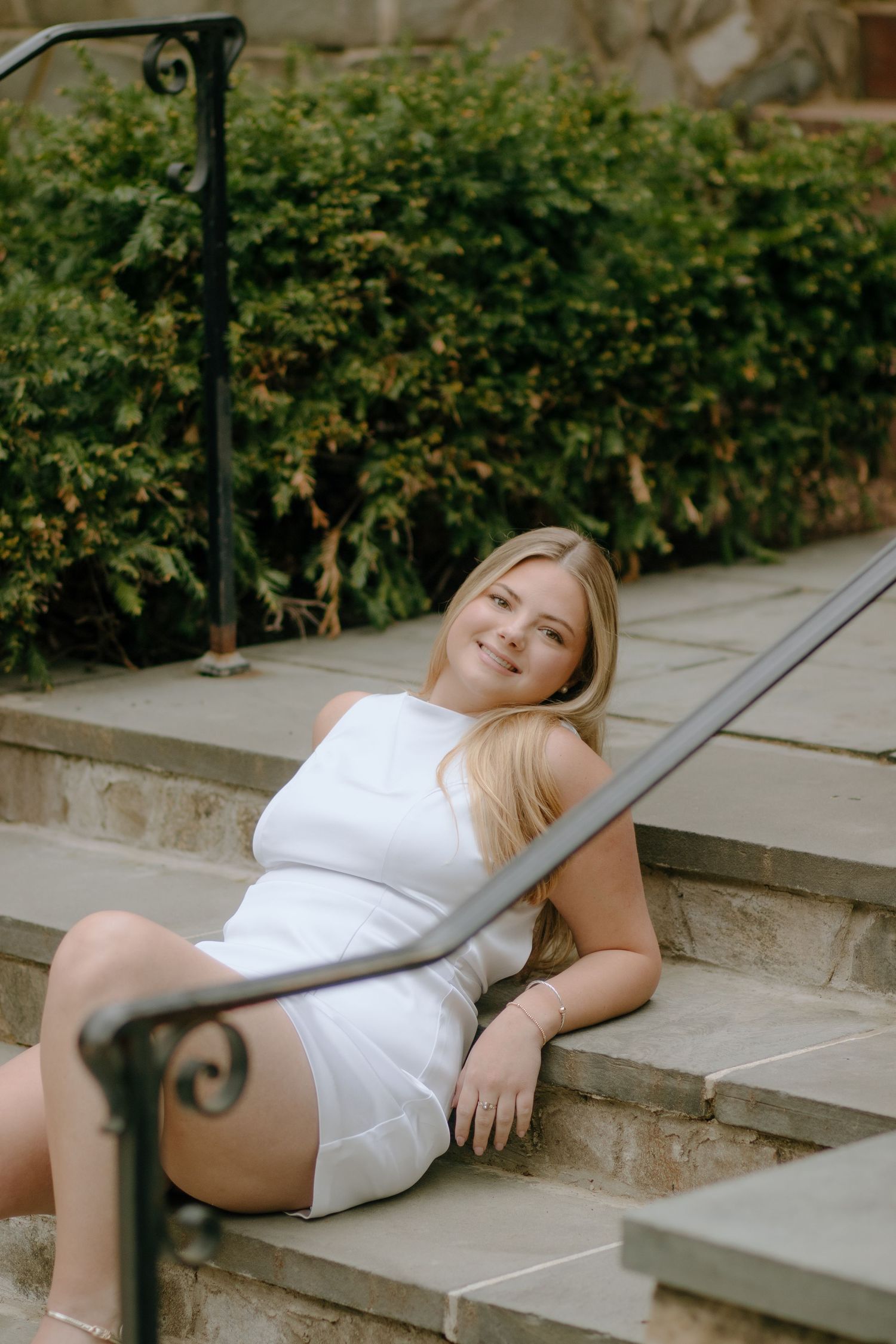 Artistic poses photographed on concrete steps with ornate metal railings.