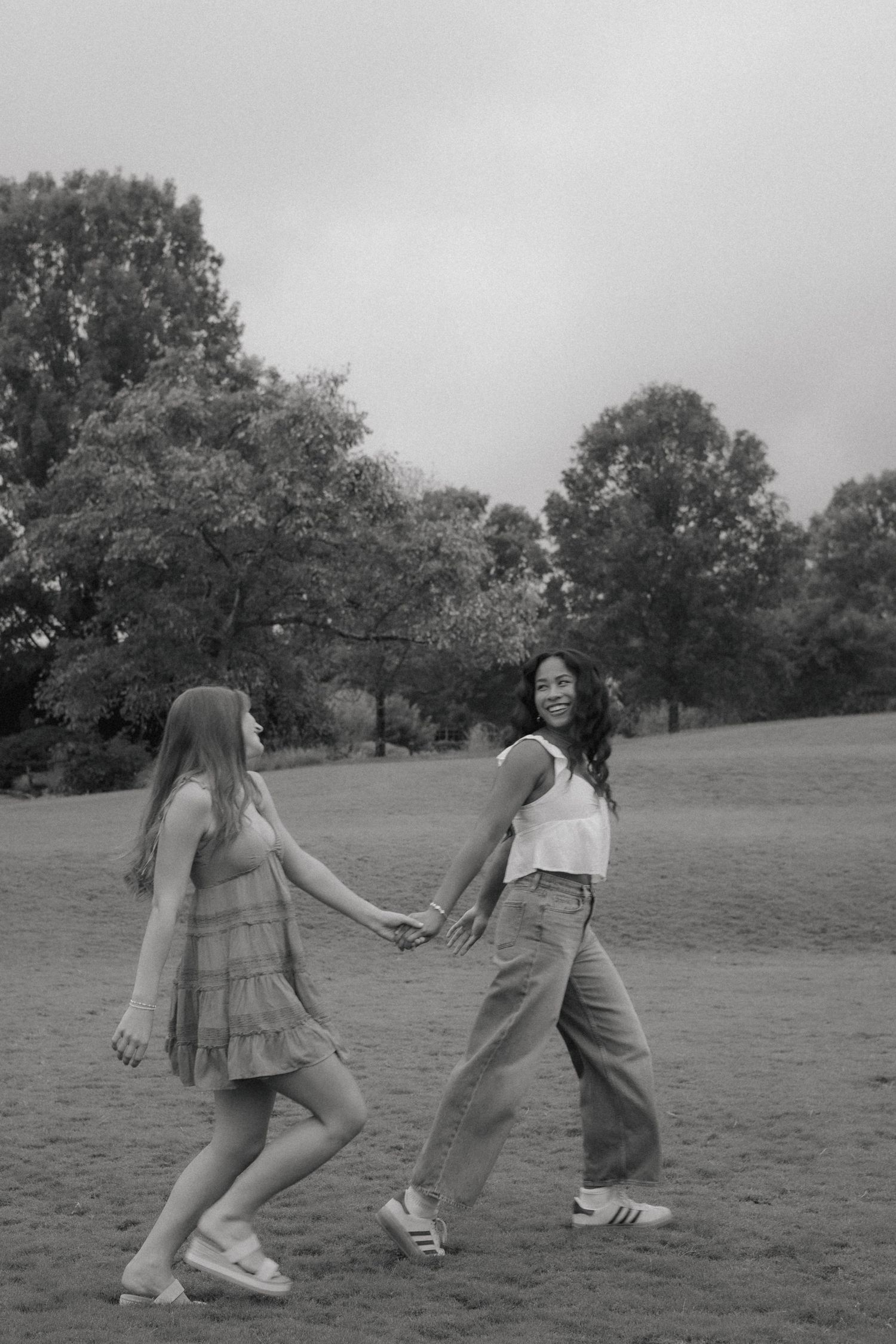 Group enjoying a playful moment in a grassy field on an overcast day.