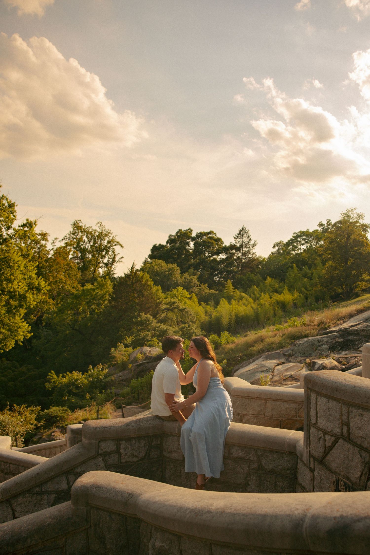 Couple sitting on stone steps railing at golden hour at Maymont in richmond, va. virginia engagement photographer