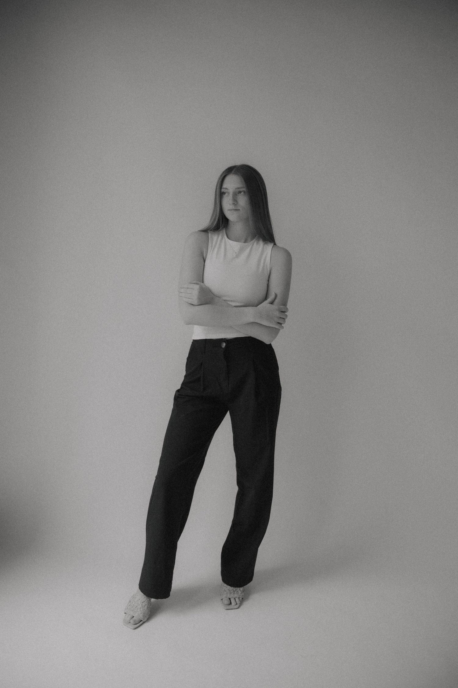 Black and white artistic portrait series showing a person in casual clothing against a minimalist studio backdrop.