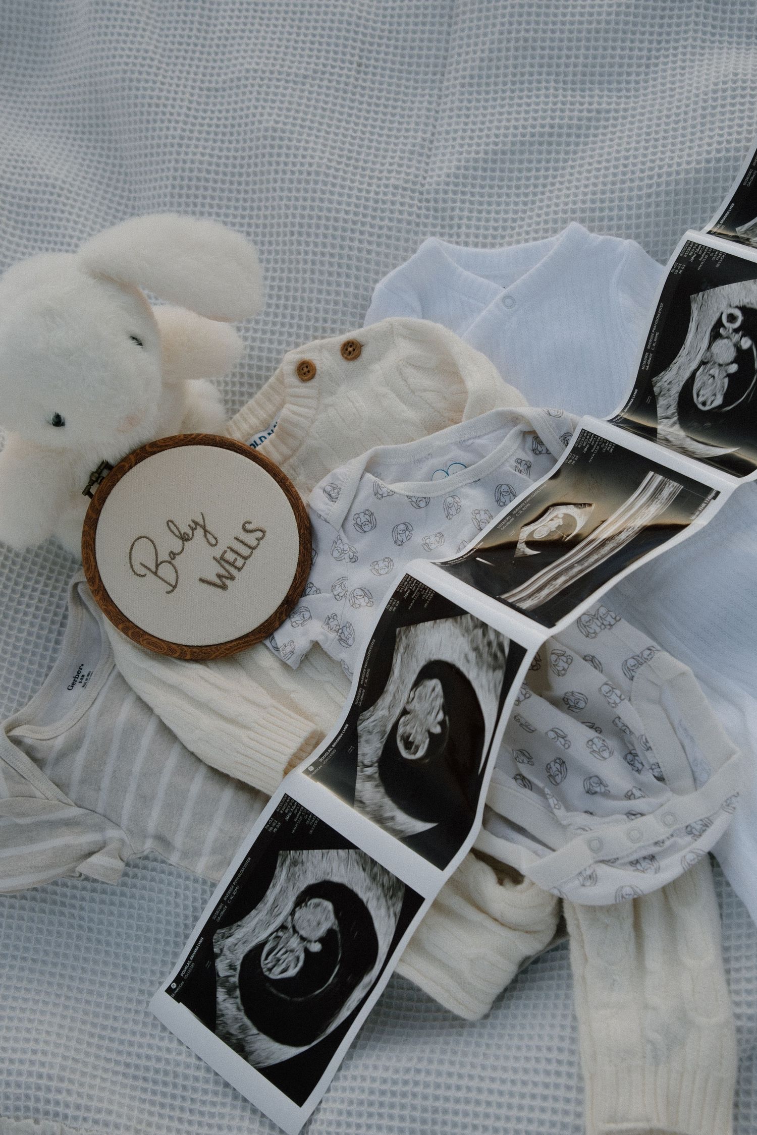 Pregnancy Announcement photoshoot prop ideas, sonogram, baby clothes, and stuffed animal shot by virginia maternity photographer