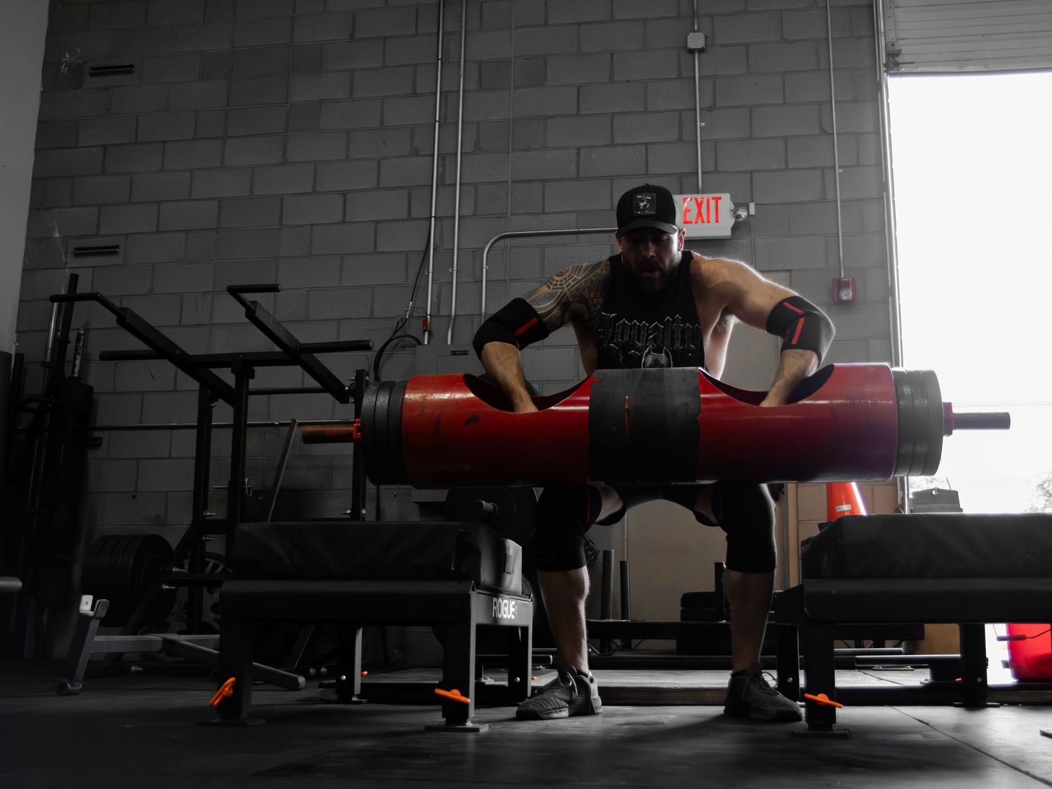 Wide angle view of gym interior with exercise equipment in low-light conditions.