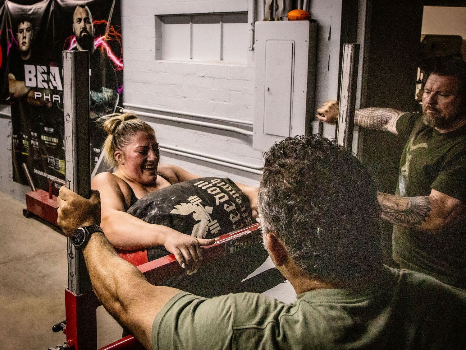 Athletes training with heavy weights in an intense gym environment.
