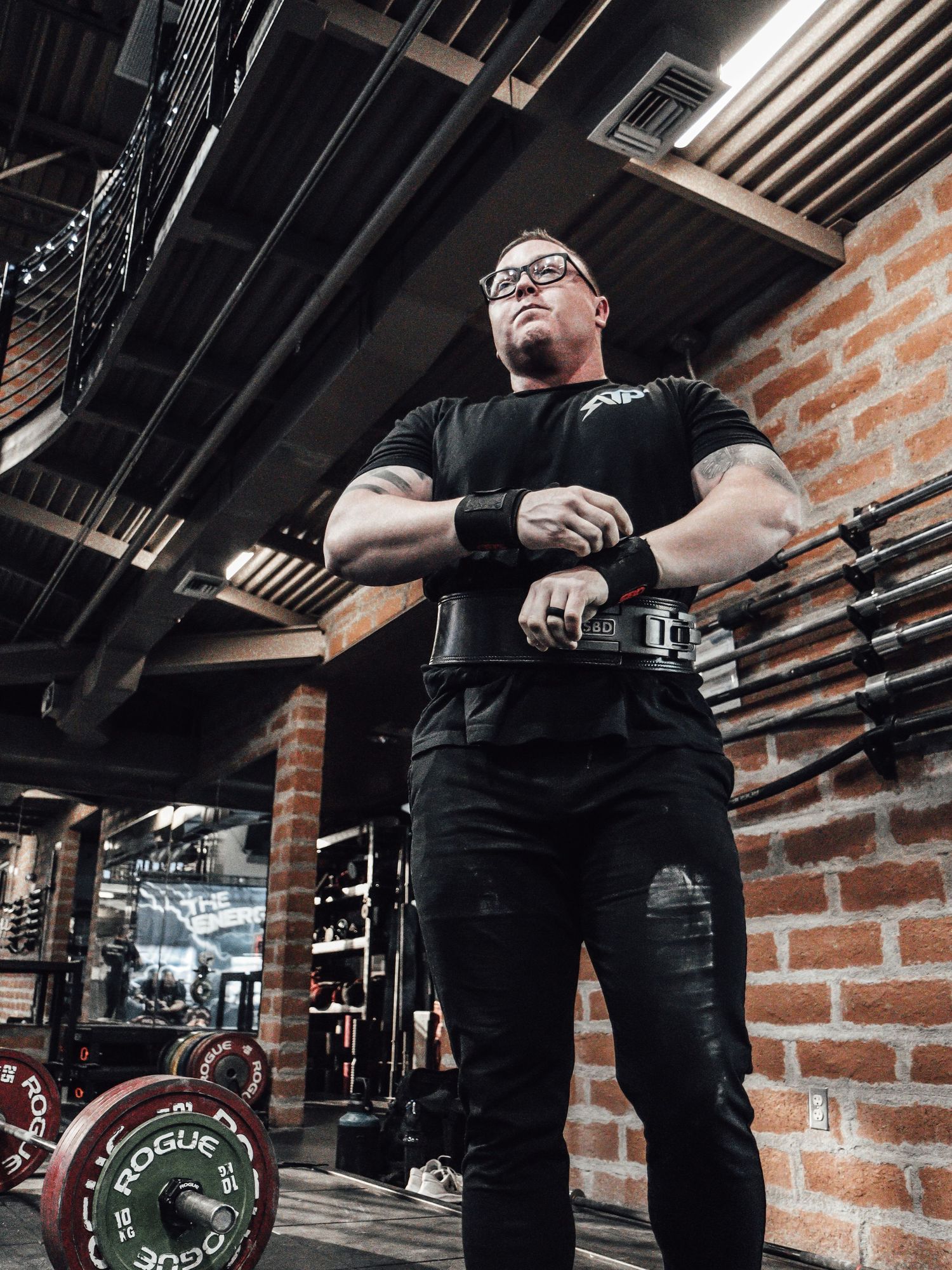 Low angle view of gym interior with exposed brick walls and fitness equipment.