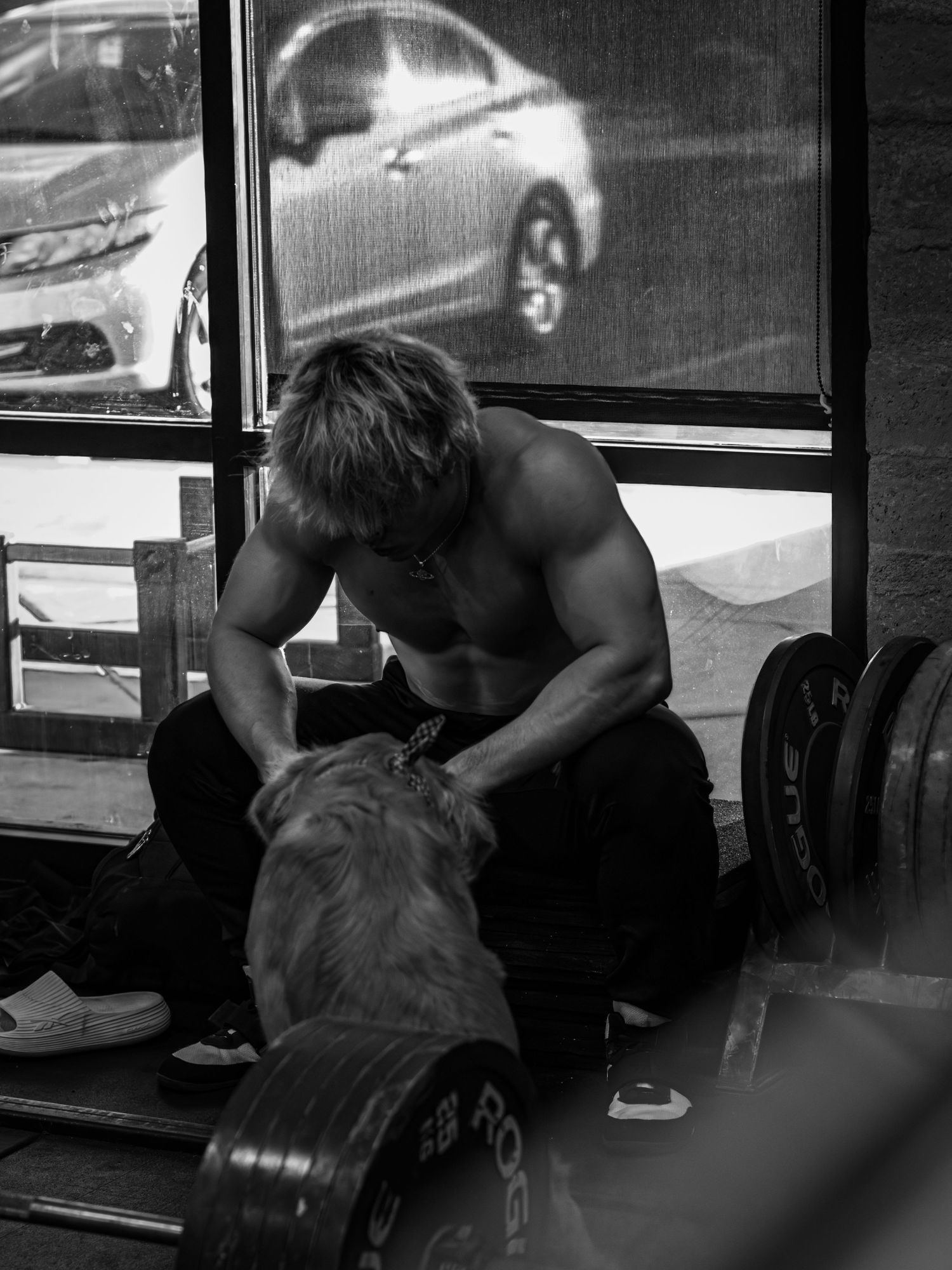 Athletes performing deadlift exercises in dramatic black and white lighting.