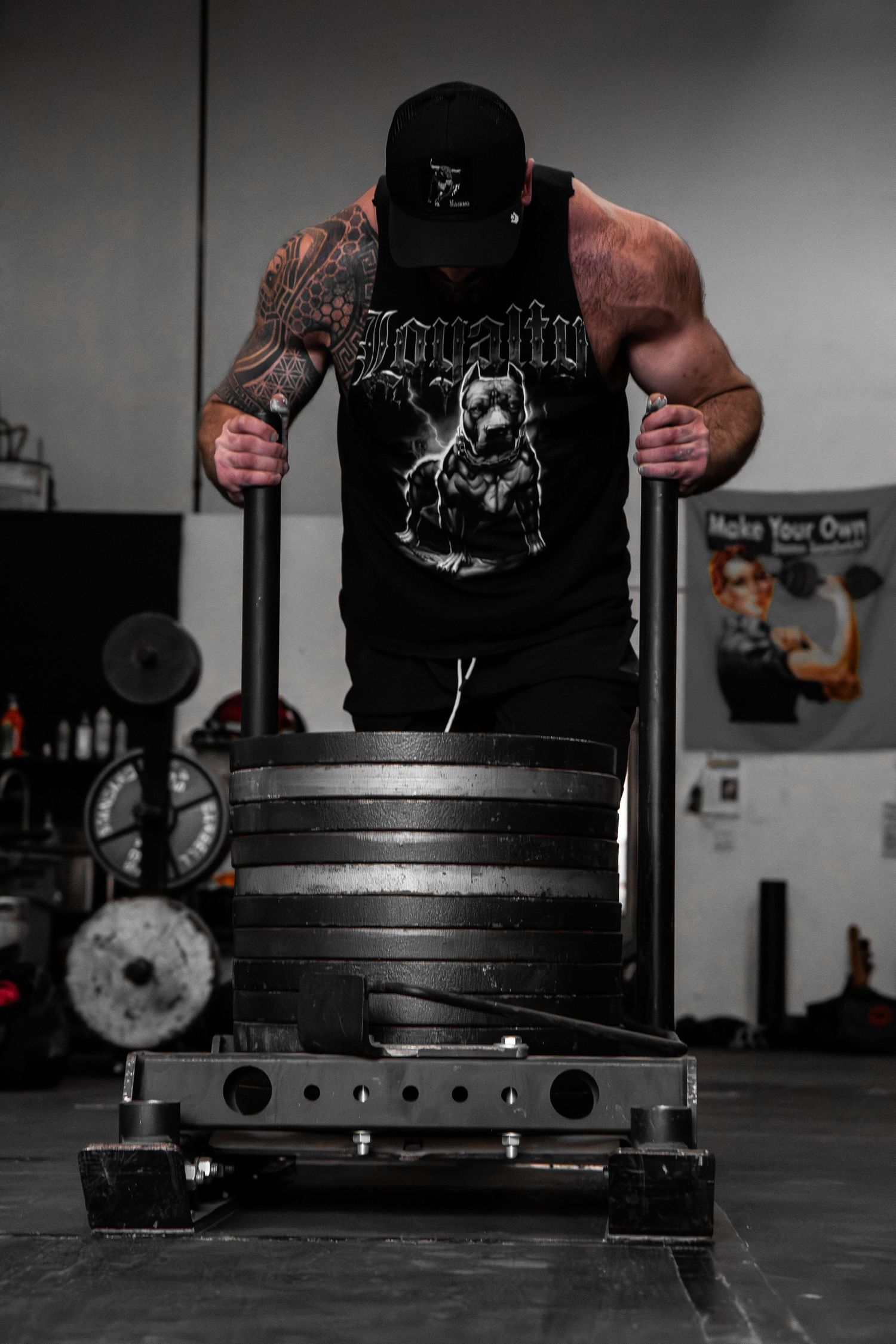 Dramatic black and white shot of weight plates stacked on barbell in gym environment.