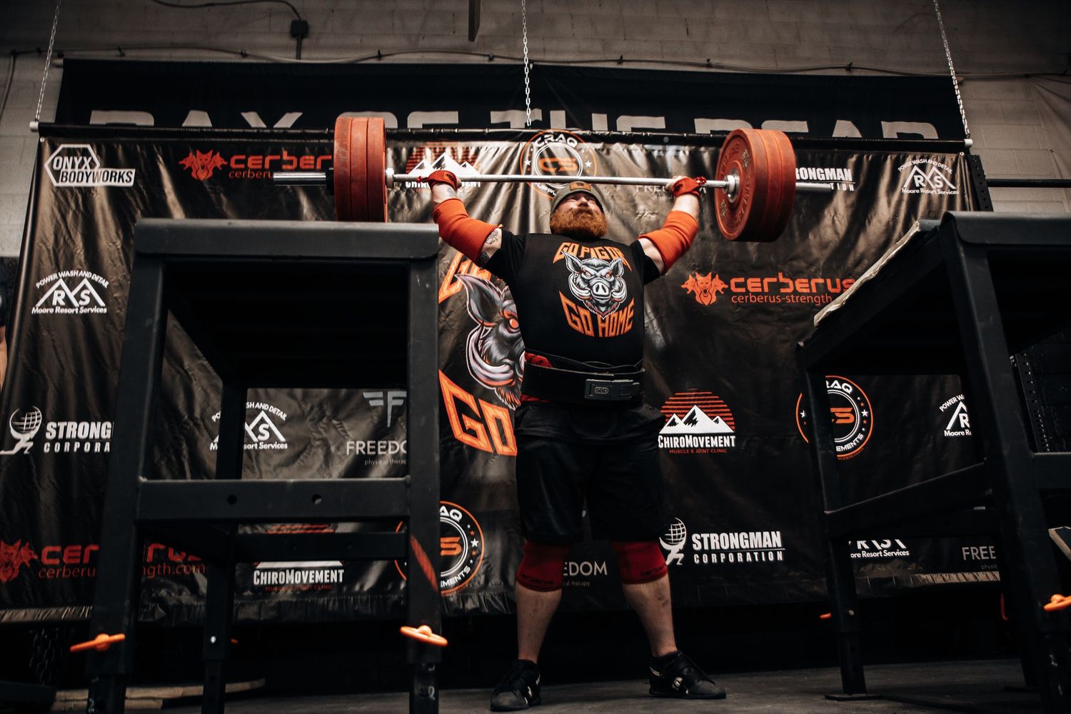 Strongman athlete competing in the behind the neck press at The Sweaty Pig gym in Murray Utah