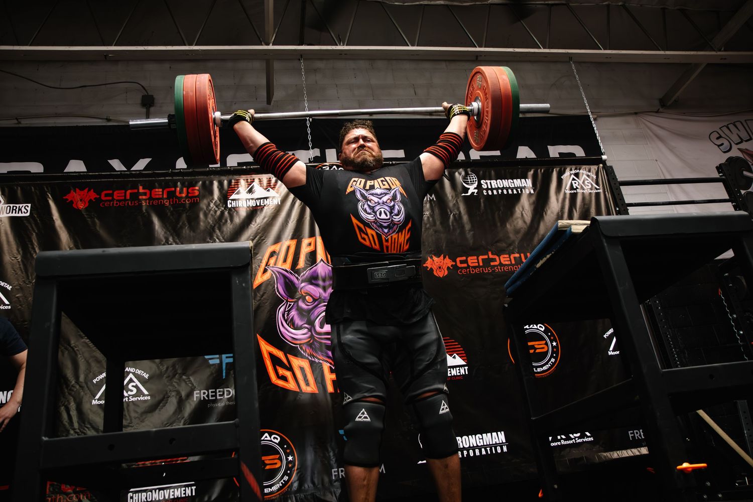 Strongman athlete competing in the behind the neck press at The Sweaty Pig gym in Murray Utah