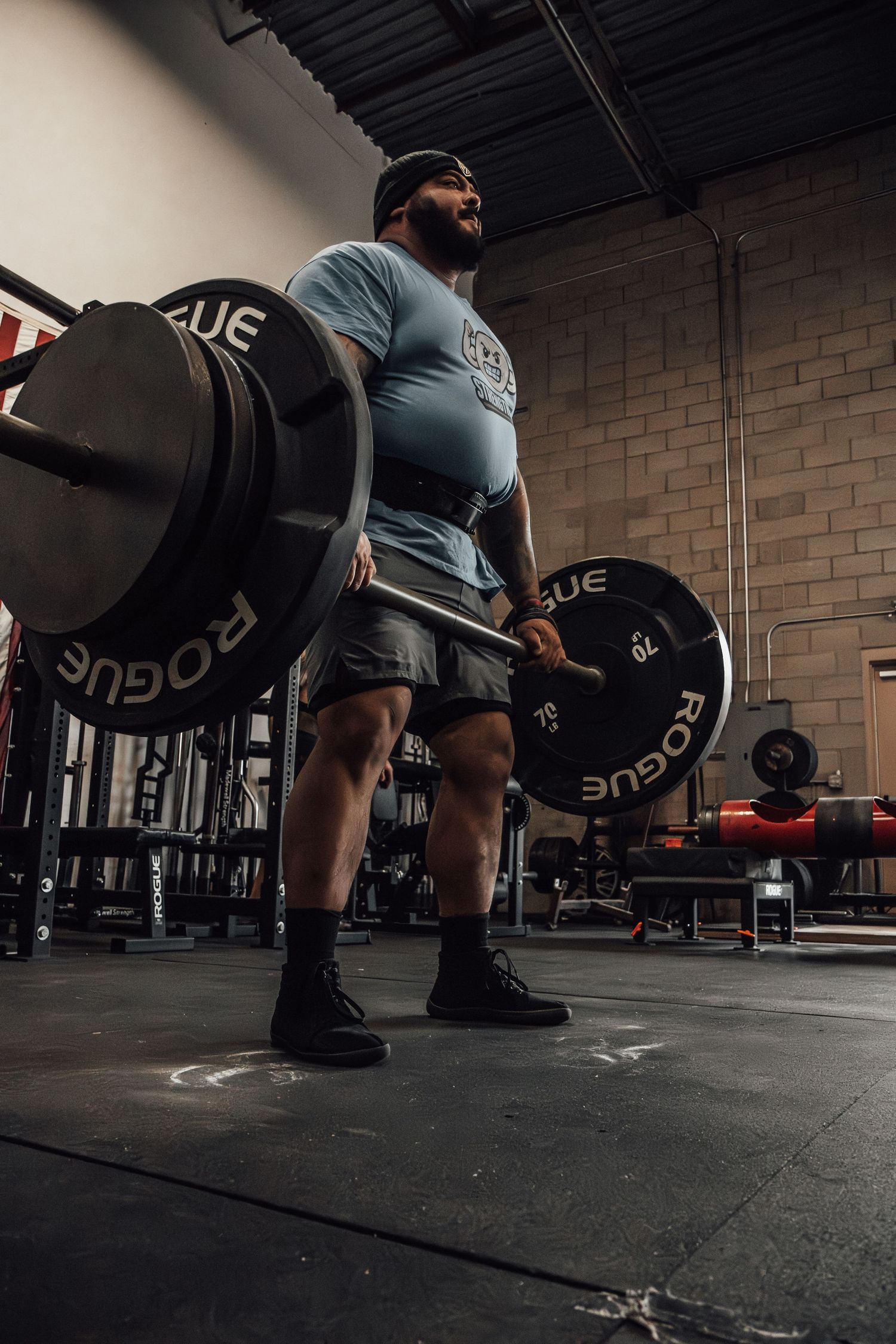 Powerlifter preparing for deadlift with heavy weights in modern gym facility.