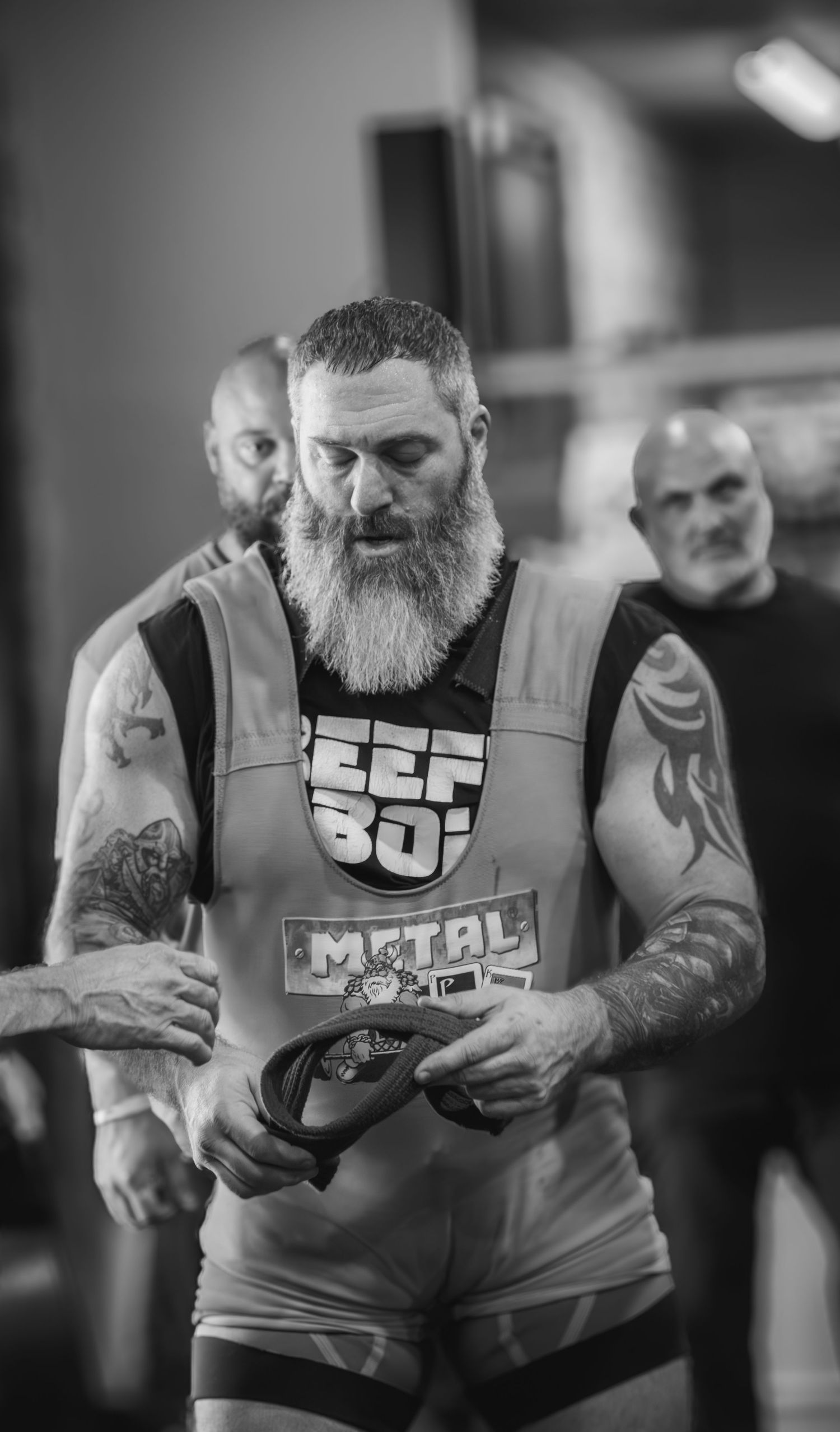 Powerlifter with beard performs an intense lift in black and white.
