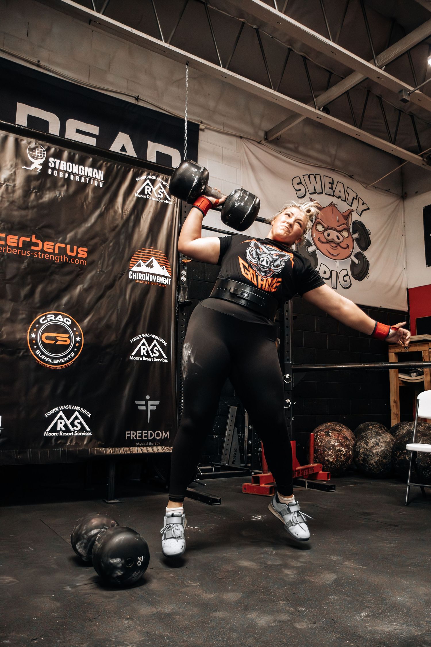 Strongman athlete competing in the dumbbell  press at The Sweaty Pig gym in Murray Utah