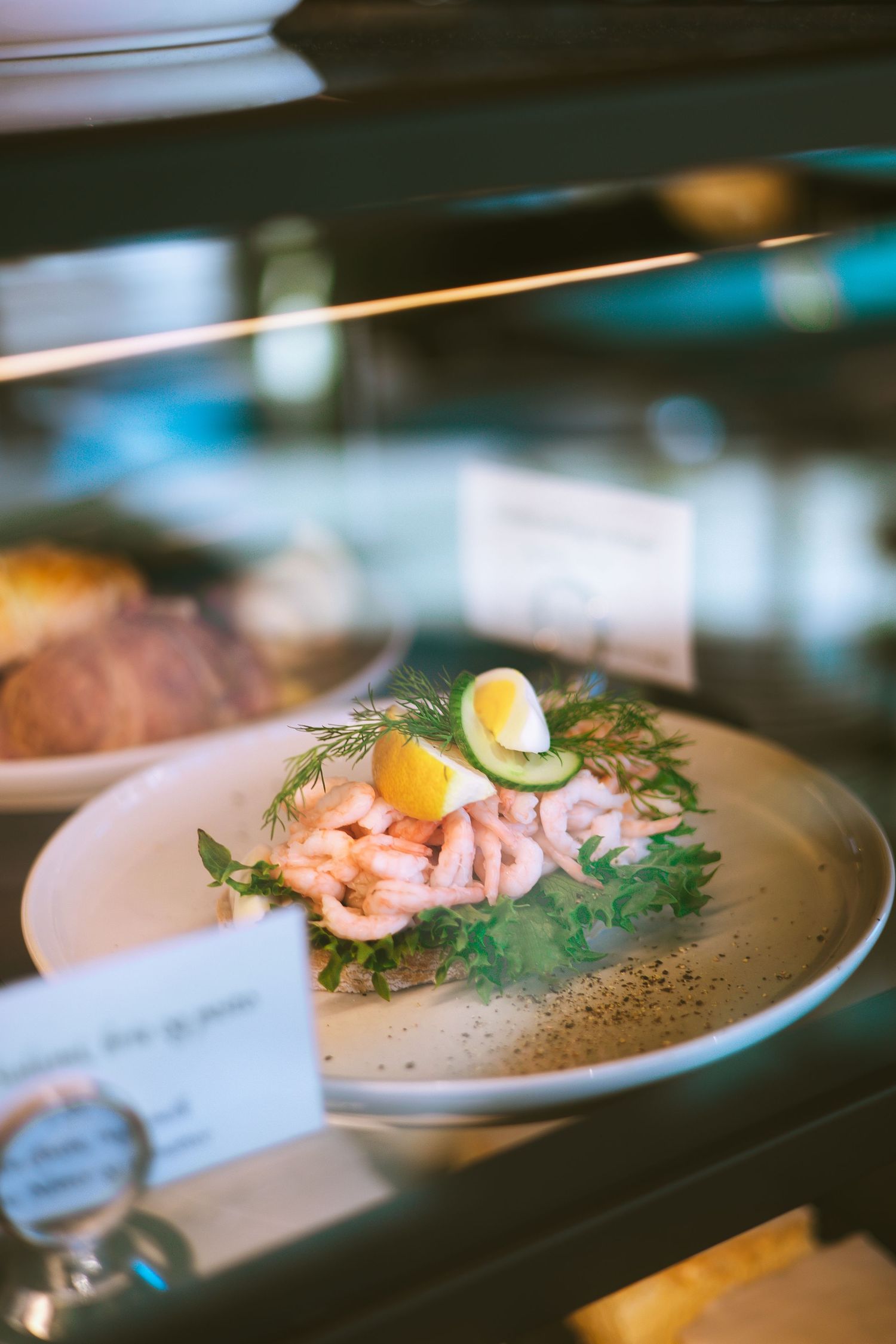 Elegantly plated seafood dishes with garnishes on white plates.